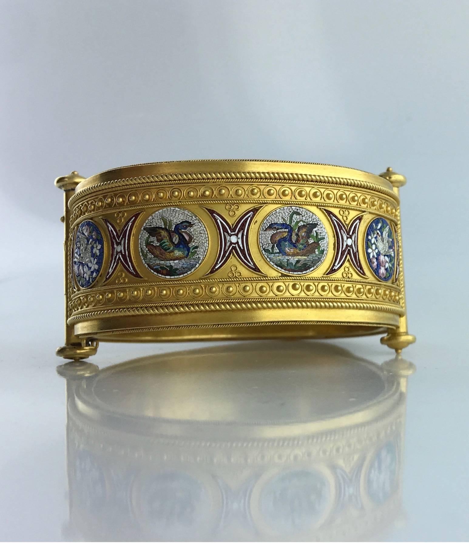 Yellow 18k gold 750 bangle punctuated by four micromosaic motifs, circa 1850.
Italian work (Rome).

Gross weight: 56.20 grams.