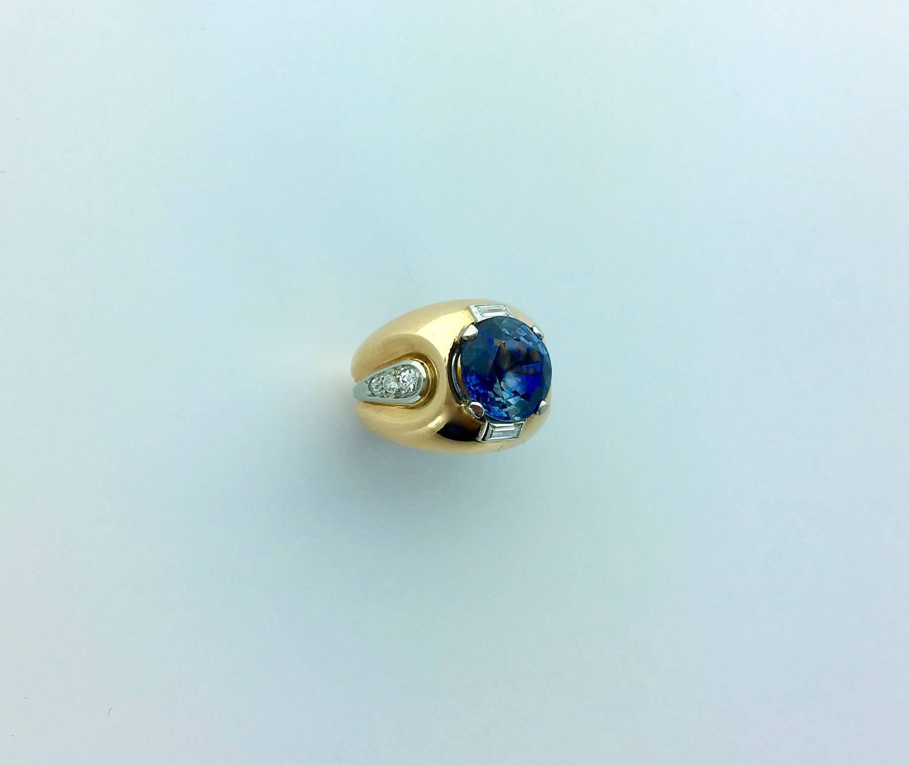 Retro design well proportioned ring in yellow gold 18k 750 centered by a round Blue Sapphire weighting 6.30 carats.
Shoulders are highlighted by platinum motifs with diamond.
Circa 1940.

Gross weight: 13.47 grams.