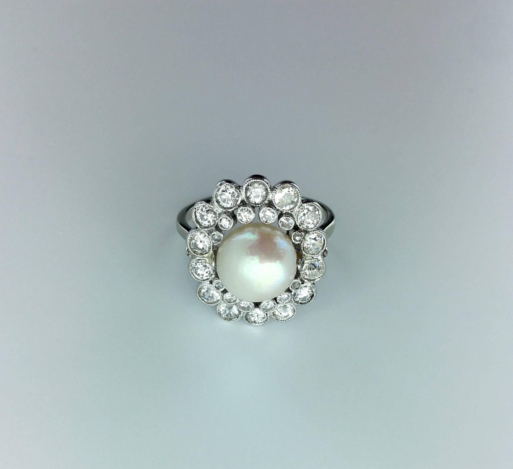 A classical French Belle Epoque model reminding Coco Chanel's inspiration, this Natural Pearl is a beauty, correct size with some light pink reflects surrounded by Old mine cut Diamond on Platinum. A Flower stylized.
Circa 1910.
French marks.

Gross