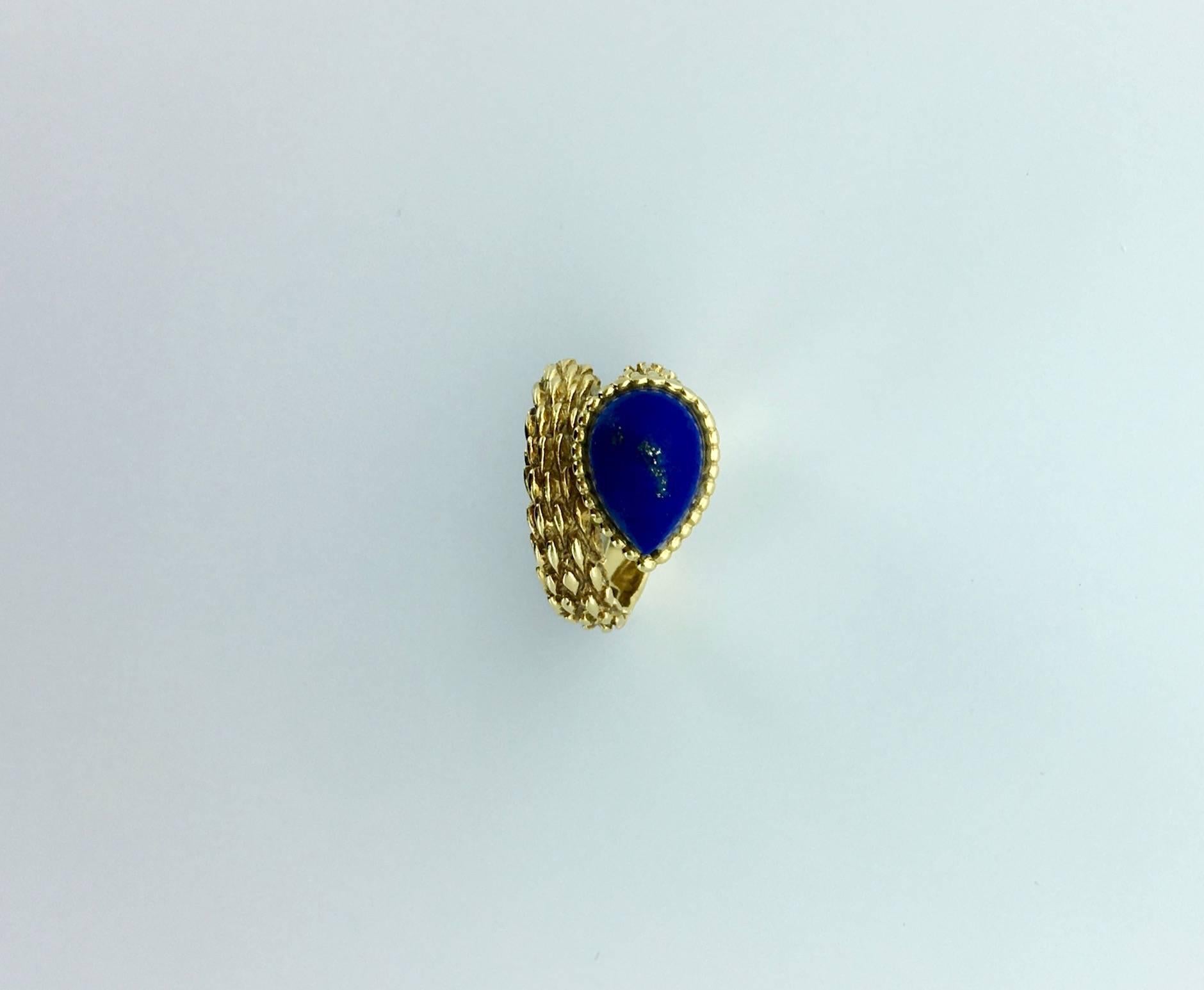 Designed as a textured bypass style band set with a pear-shaped cabochon lapis lazuli.
Signed Boucheron
French mark and maker’s mark.
Ring Size Us: 3 3/4 (46).
Gross weight: 9.40 grams.
