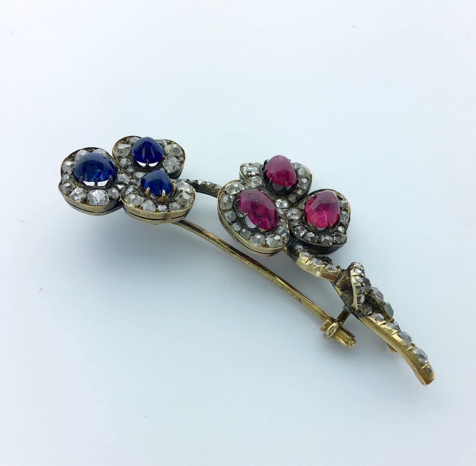 This Clover brooch is Amazing. The cabochon Sapphire and Ruby are Burmese non heated of incredible color and brightness surrounded by Old mine cut Diamond.
French marks and maker's mark (F.K.)
Circa 1890.

Gross weight: 13.11 grams.