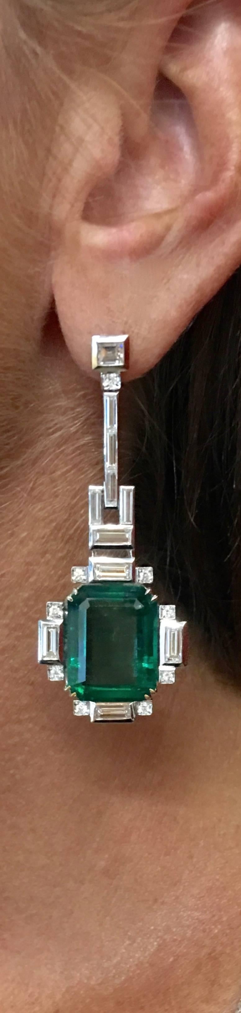 Mesmerizing Pair of Zambian Emeralds totaling 26.35 carats, mounted on Pendant Earrings in White Gold and surrounded by Diamond. 
Art Deco design realized in Mid-20th Century.

The two Emeralds are Zambian Moderate Oil accompanied by Swiss