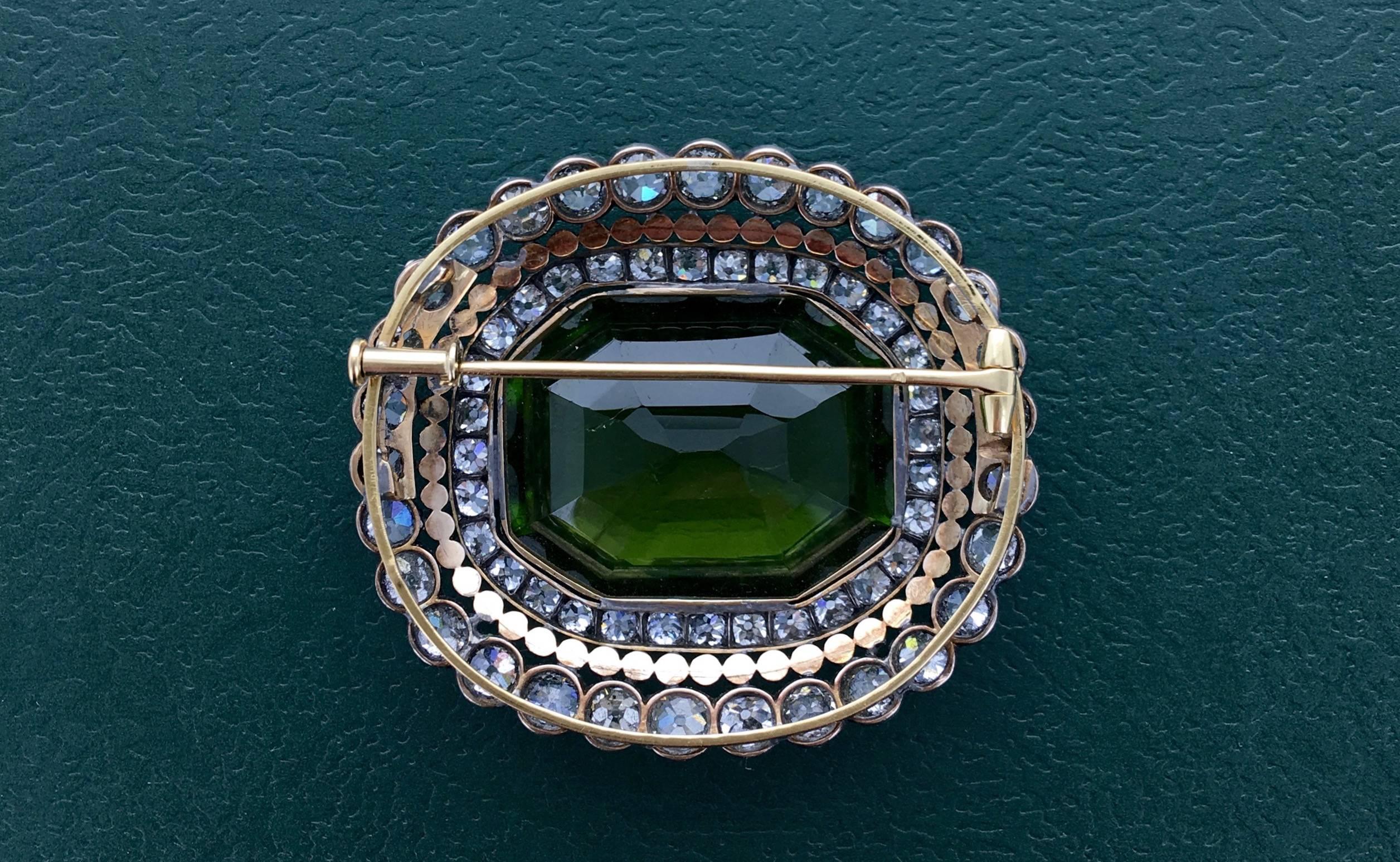 This piece is impressive and magnificent. The peridot is very significant and beautifully surrounded by Old-mine cut Diamond on silver and gold.
The quality of work is perfect.
Late 19th Century.

Dimensions: 2.36x1.77 inches (6.00x4.50