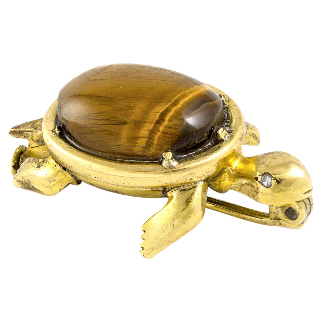 The 1960's French Cat’s Eye Cabochon on Yellow Gold 18k Turtle Brooch Clip is a stunning and sophisticated accessory that exudes elegance.

This brooch features a beautiful cat’s eye cabochon, a type of gemstone known for its mesmerizing chatoyant