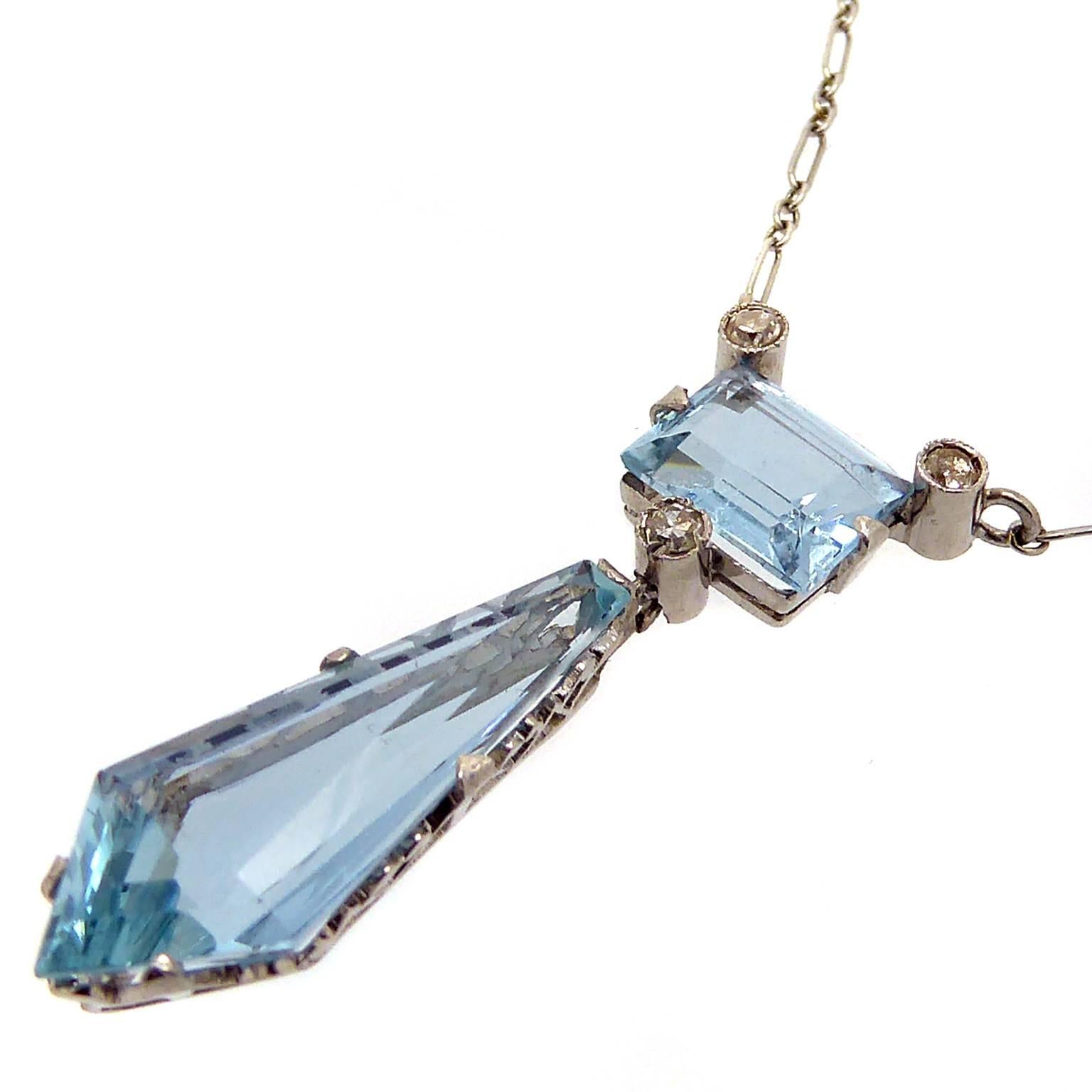 An aquamarine and diamond set drop pendant set with one lozenge shaped aquamarine suspended from a single cut diamond drop which, in turn, suspends from a rectangular mixed cut aquamarine.  To each top corner of the rectangular aquamarine is a