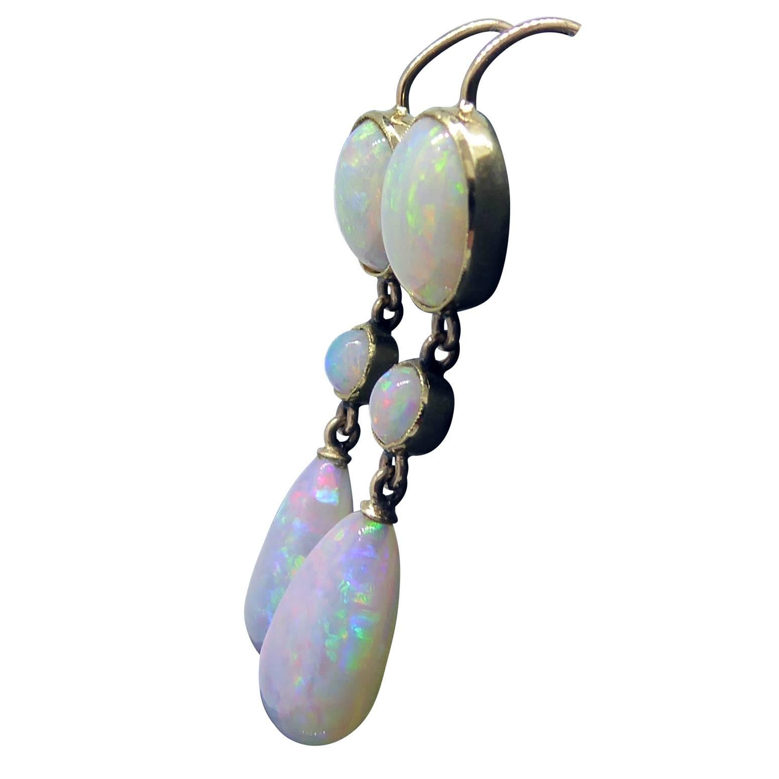 Absolutely delicious drop earrings featuring a tear-drop shaped opal suspended from round and oval cabochon cut opals.  The colours of blue/green and orange flash sensationally, a stunning display which is amplified as the earring sway with each