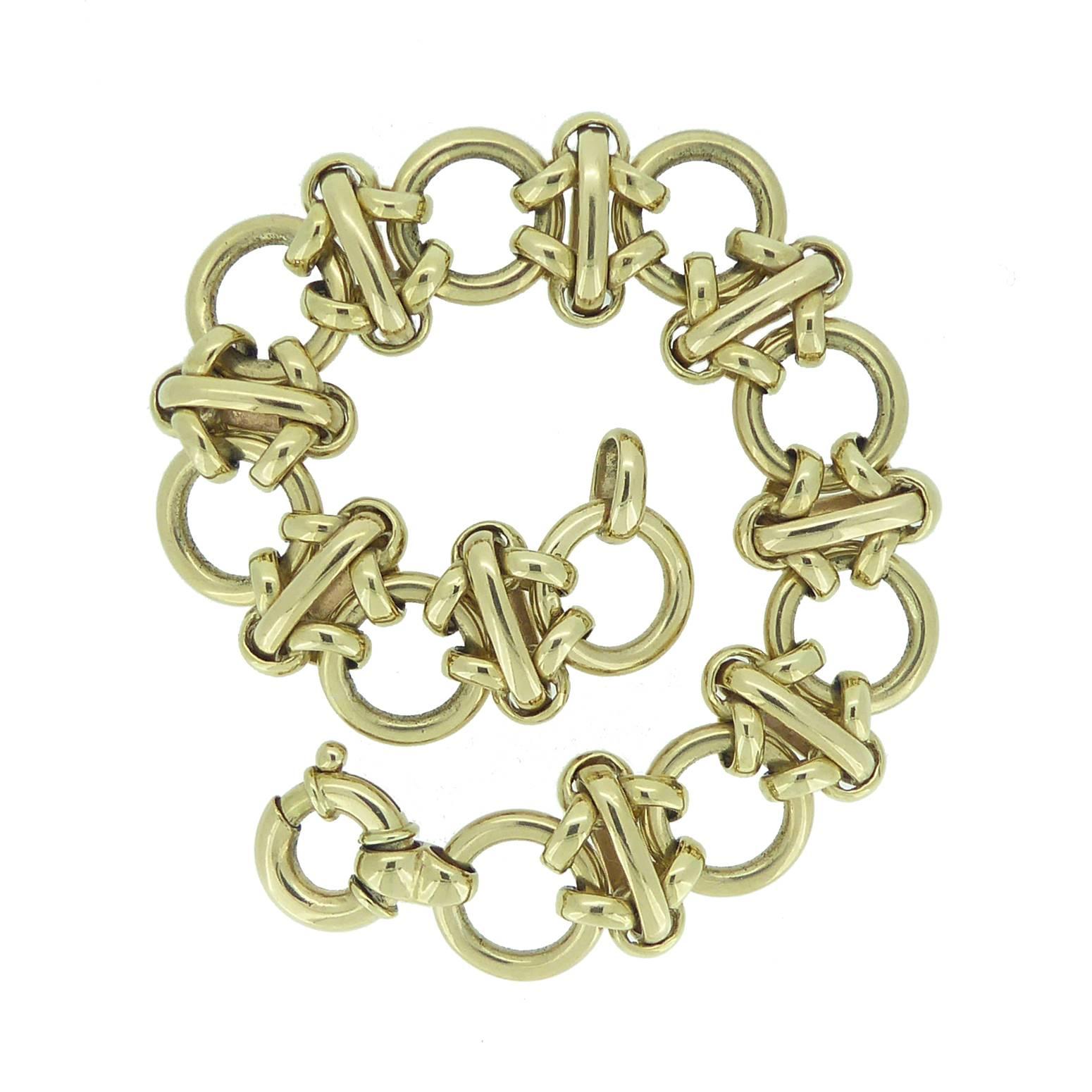 In remarkably good condition this fancy link bracelet is typical 1990's vintage style.  It's fashioned from 10 large doughnut shaped yellow gold rings approx. 13mm diameter.  Each of these links is connected by double gold rings to elongated oval