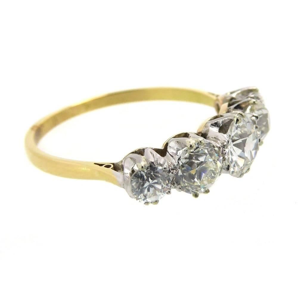 A stunning antique vintage diamond ring set with five old cut diamonds all in claw settings to white metal rex coronets.  The band is yellow metal, which is unhallmarked and reacts to testing as 18ct gold, with shoulders tapering to the
