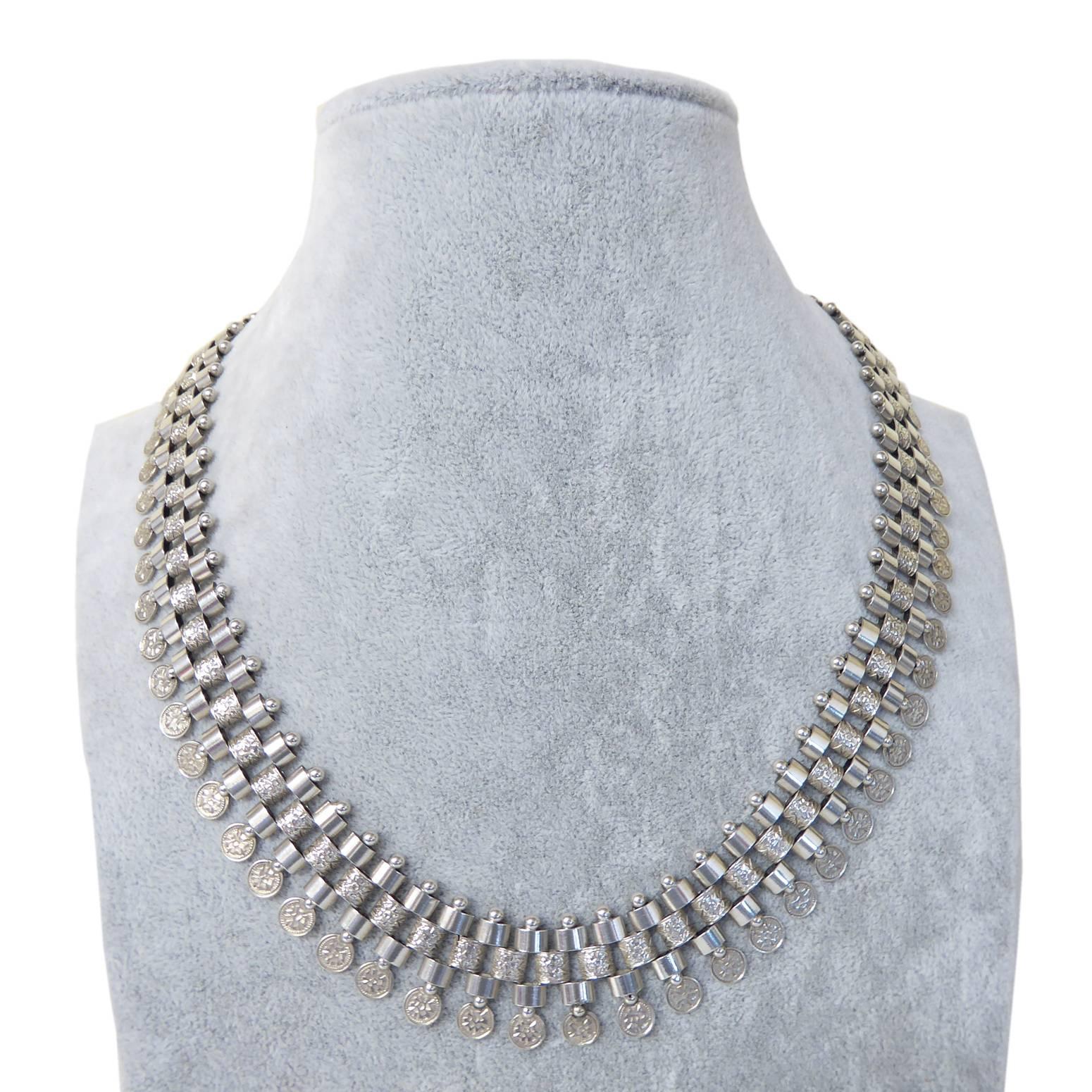 An imposing collar style necklace typical of the Victorian era from which it dates.  Two rows of plain polished links are separated by a patterned link row in a brick style.  The plain polished links are bevelled to one side whilst the other is flat