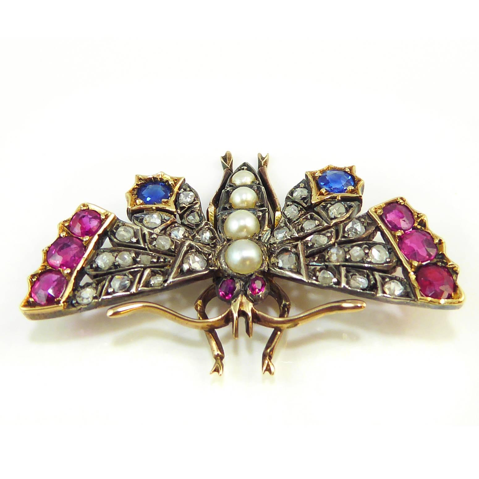 An exceptionally detailed and fine quality Victorian butterfly brooch/pendant.The wings are beautifully crafted and adorned with old rose cut diamonds with ruby and sapphire accents to the tips.  The butterfly body has been created using quite