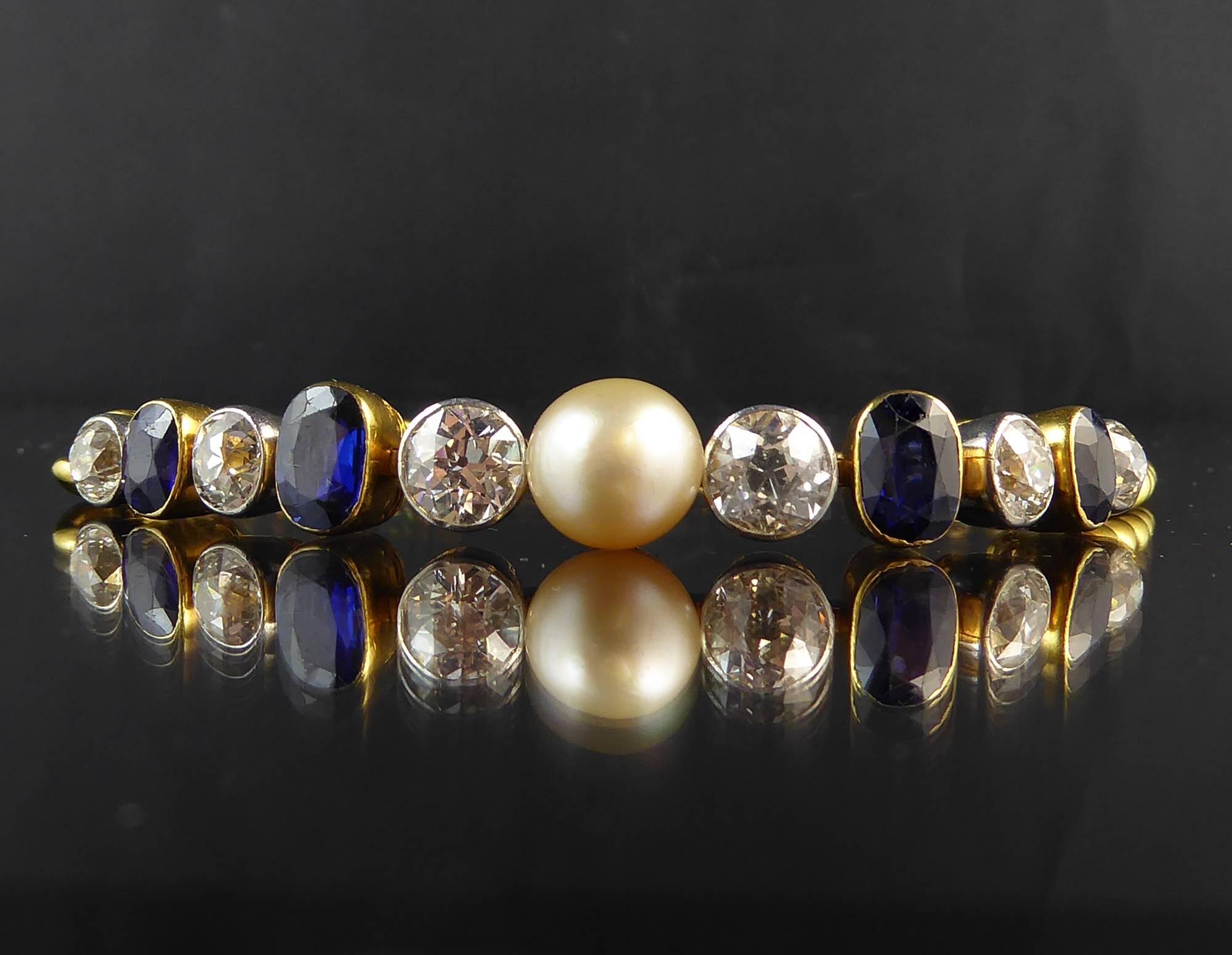 Created in the 1920s/1930s this imposing line bracelet centres on a large creamy white pearl, assessed as natural, and flanked on either side by three old European cut diamonds in white rub-over settings to articulated collets.  Between the diamonds