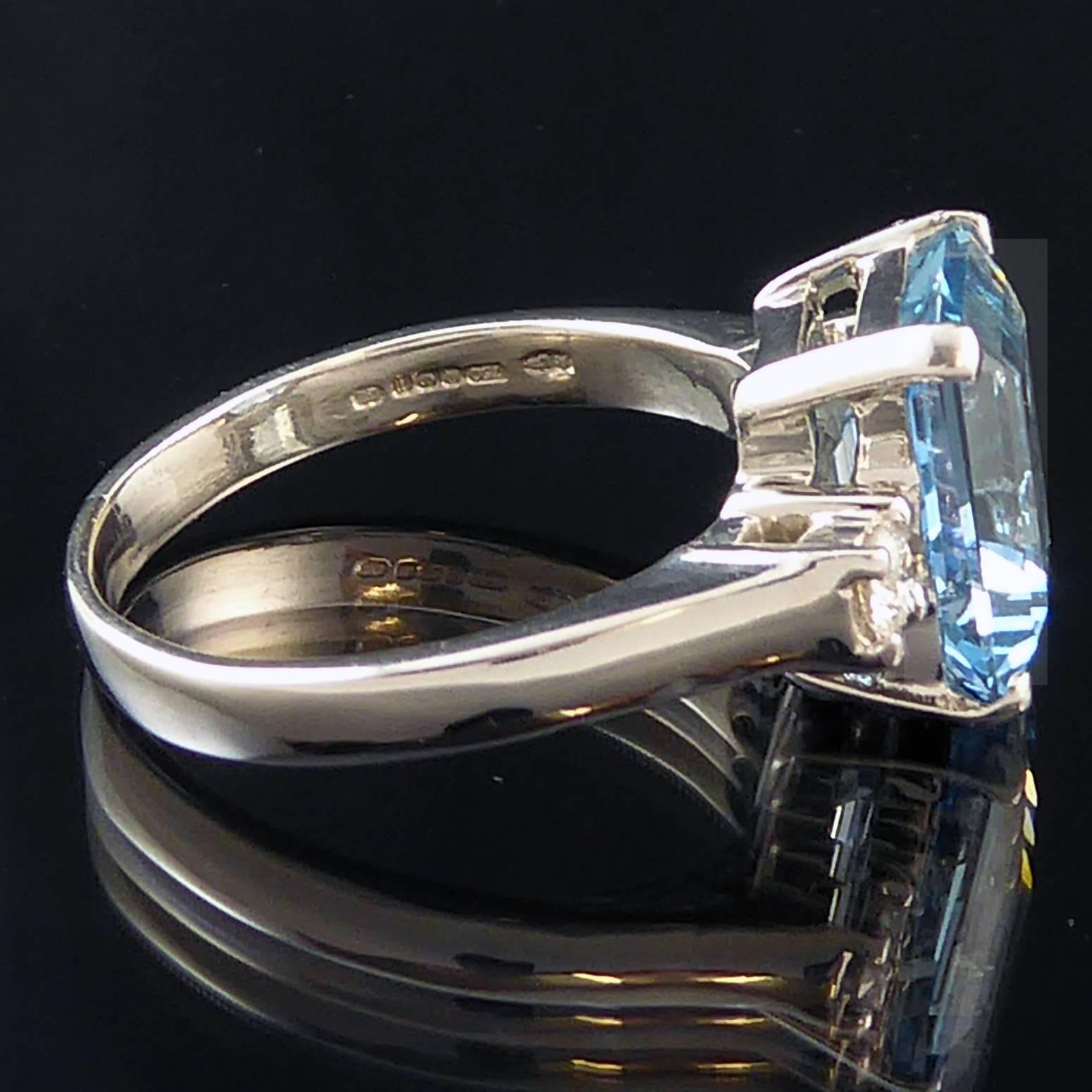 An aquamarine and diamond three stone ring set to the centre with a fabulous emerald cut aquamarine of strong blue/green golour. All the gemstone are four claw set in 18ct white gold to double bezel coronets.  Solid "D" shaped shoulders