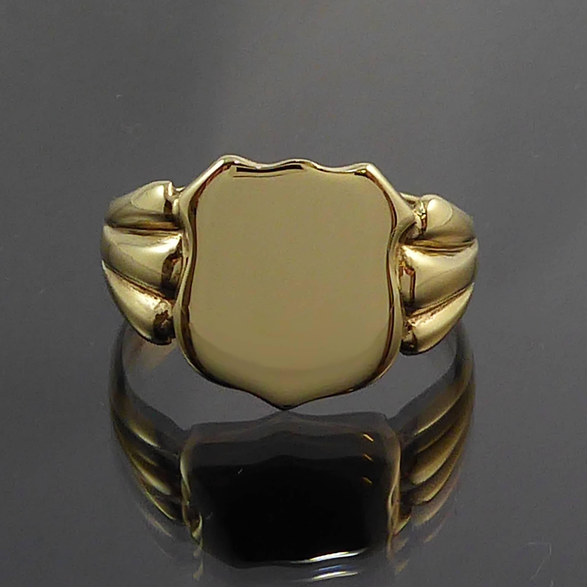 A masculine and rugged signet ring from the 1950s in 9ct yellow gold with a classic shield shape front.  Grooved shoulders are an attractive decorative detail and lead to a flat cross sectioned band.

The condition of this ring is absolutely