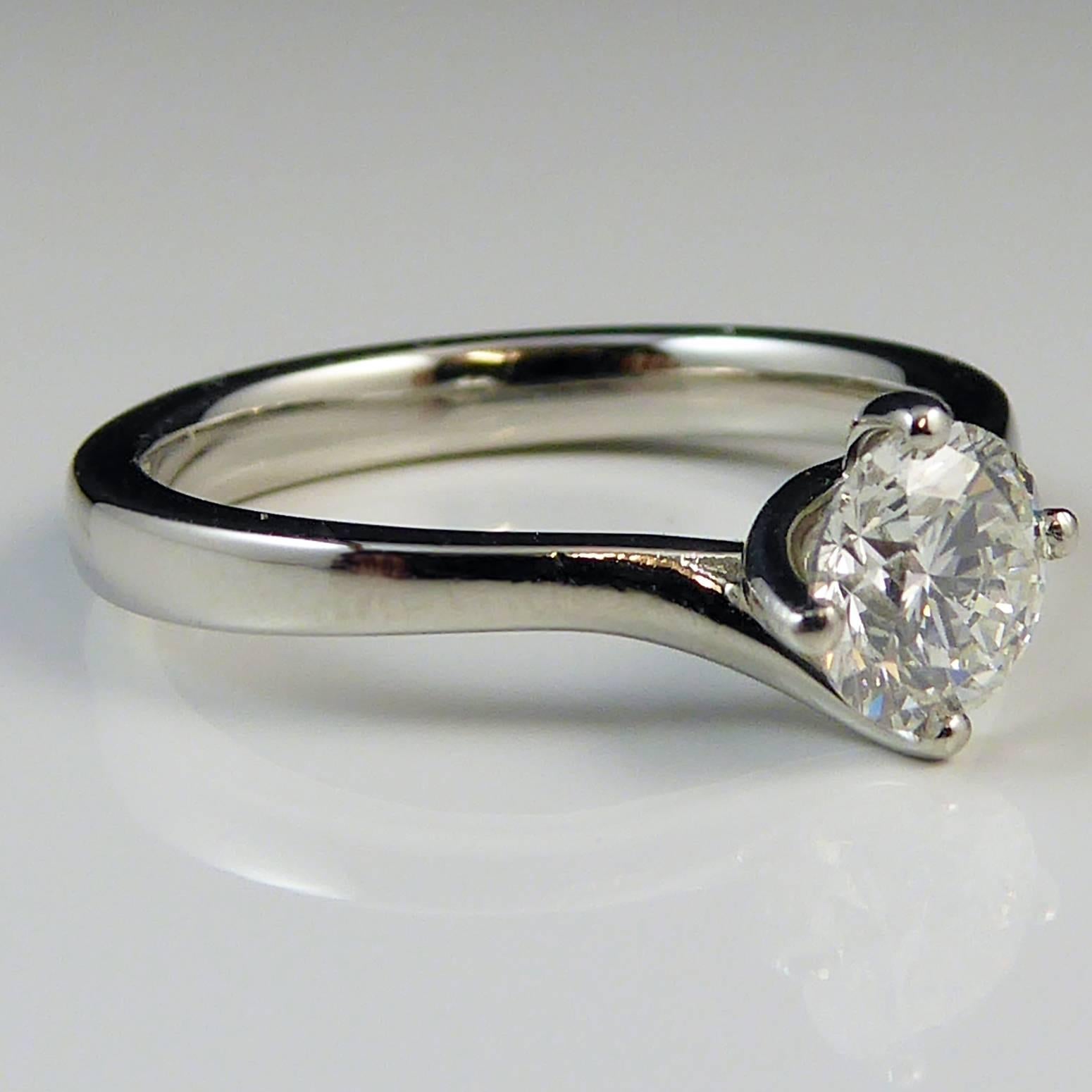 Pre-owned single stone ring set with a brilliant cut diamond estimated at 0.55ct. The diamond is held in four claw setting to shoulders twisting slightly to either side of the stone to a "D" shaped white band.  Hallmarked at the Birmingham