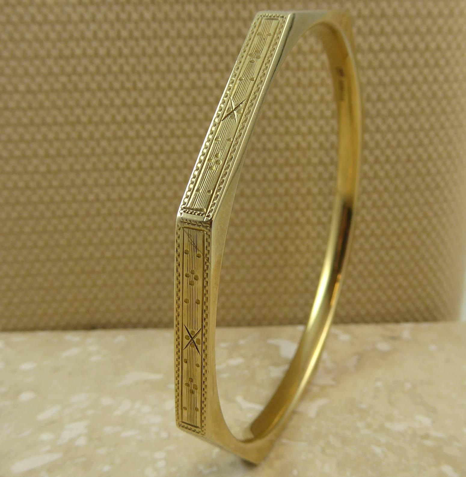A superb Art Deco slave bangle in a typical angular design.  The outer edge comprises eight hollow rectangular sections which have been adorned with a machine engraved reed and star pattern within a dentil-like border.  

The inside of the bangle is