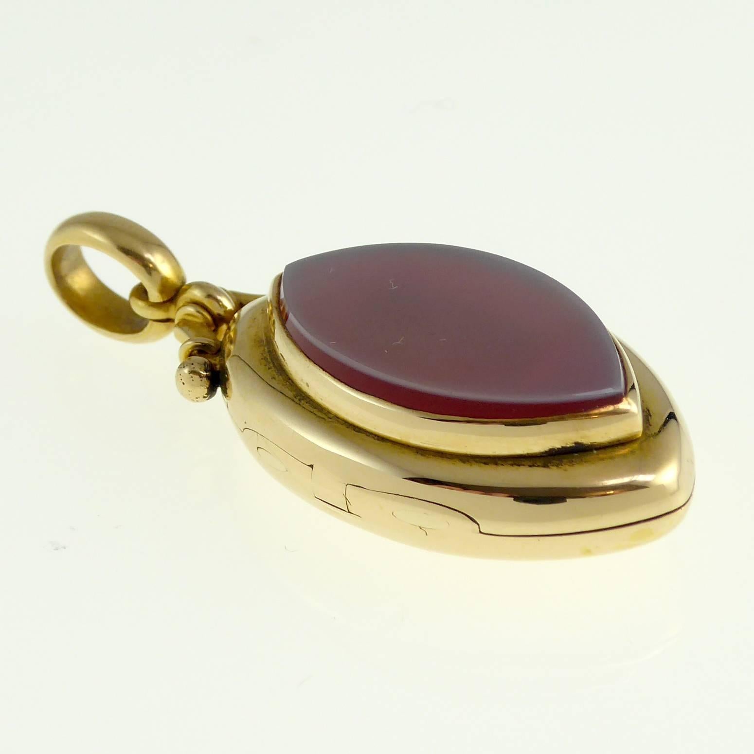 A very neat  and easy to wear Vicorian picture locket in a marquise shape with a raised platform to the front which has been set with a carnelian cut to mirror the shape of the pendant. 

The rounded edges of the pendant give a very tactile quality
