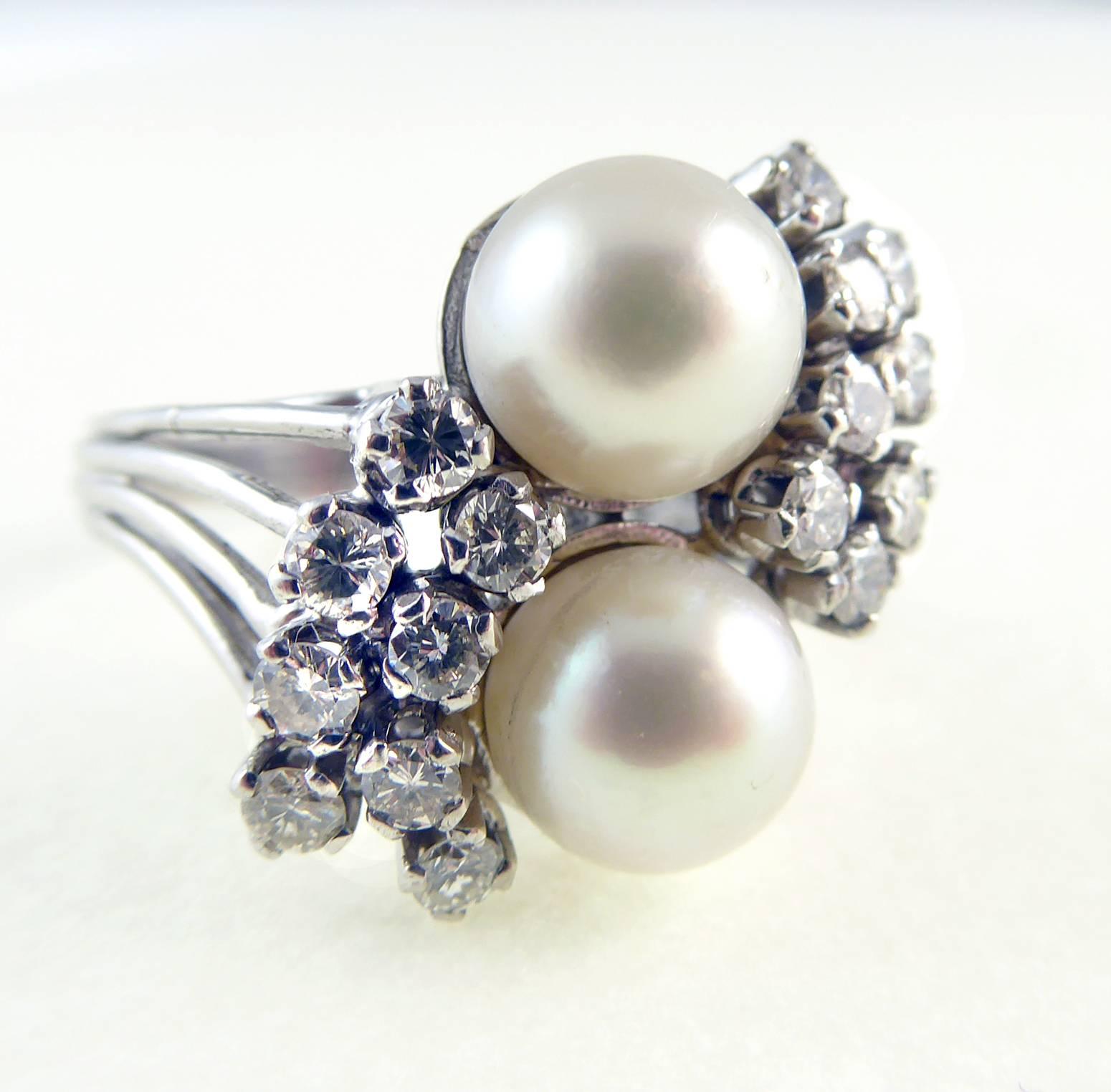 A glorious confection of diamonds and pearls has created this most stunning cocktail ring.  

The pearls have been set at a slight angle down the finger in white metal cup settings. 

 A double row of diamonds are gathered around opposite sides of