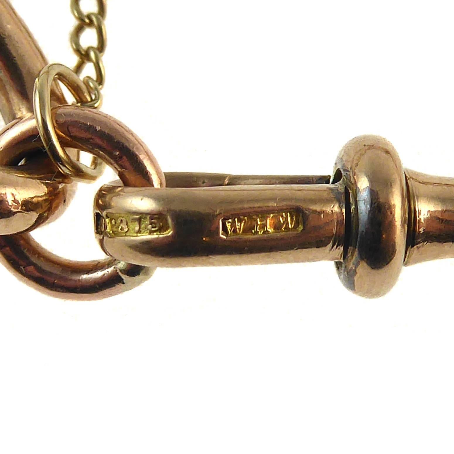 Created from a Victorian watch Albert chain, this old gold bracelet comprises elongated oval links with an approximate total length of 8.5 inches.  Fastening with the typical swivel, or dog, clip catch, the bracelet also has the added benefit of a