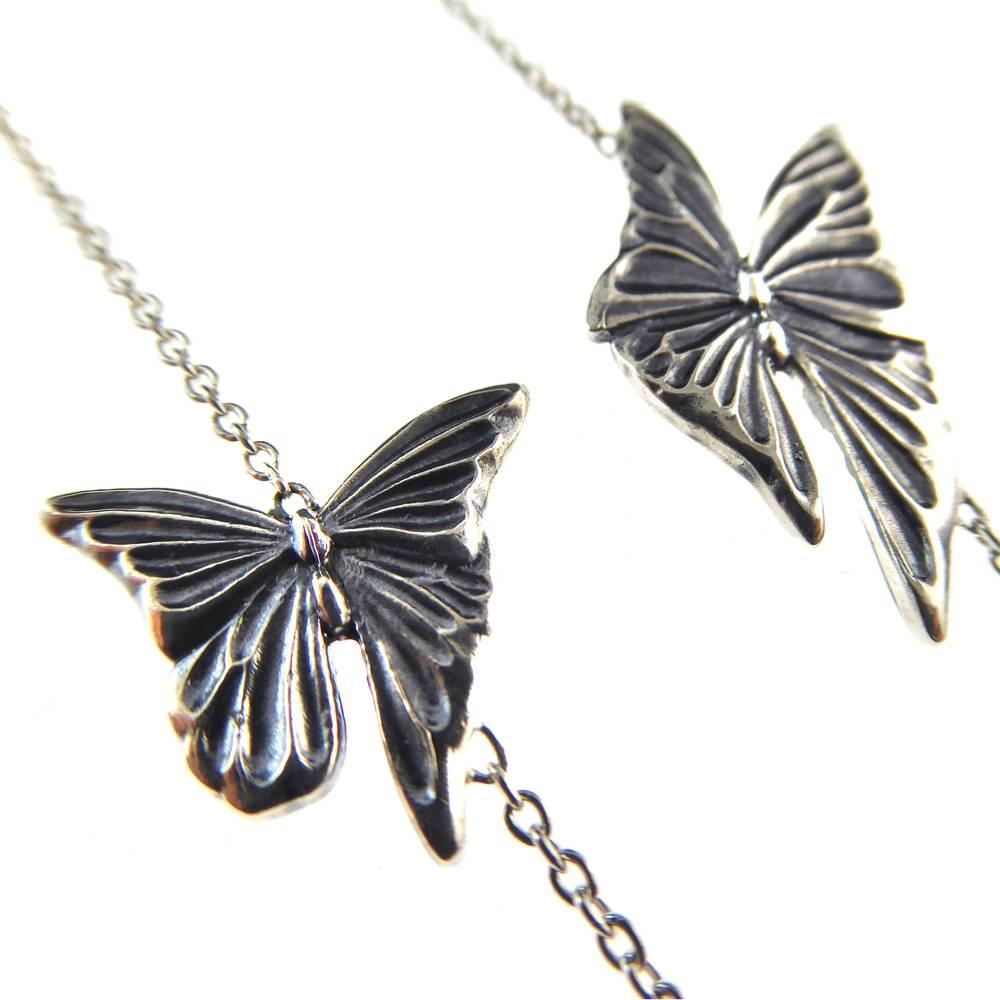 A long silver necklace, or sautoir, from the Danish design house of Georg Jensen.  Part of the Jordan Askill collection of silver jewellery designs, the necklace comprises butterflies of varying sizes in oxidised silver set at intervals along the
