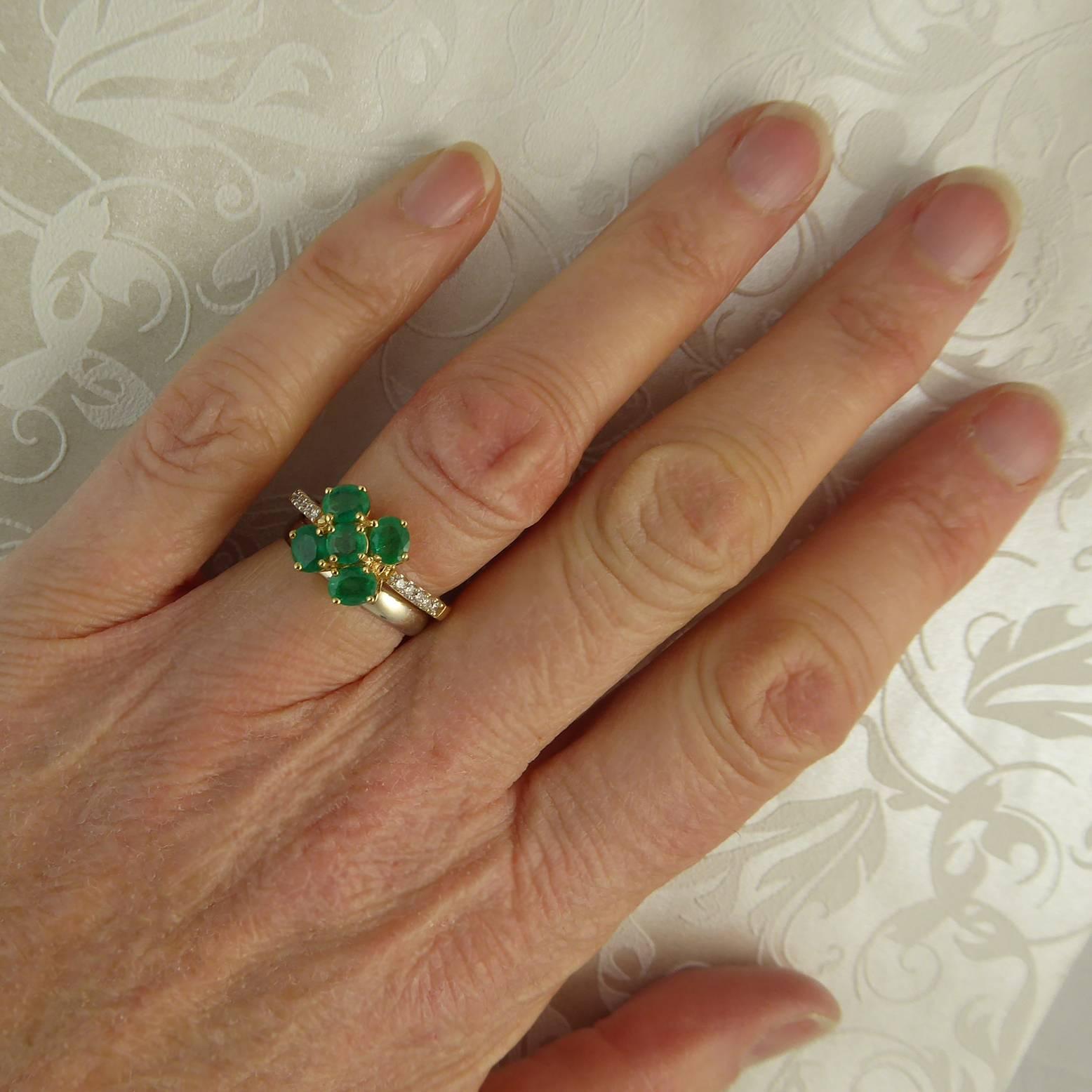 A vintage ring from the 1980s set with a cluster of emeralds, four oval emeralds surrounding a round emerald suggesting a four leaf clover design.  the emerald are a nice strong colour and have been claw set in contasting yellow gold claws. A neat