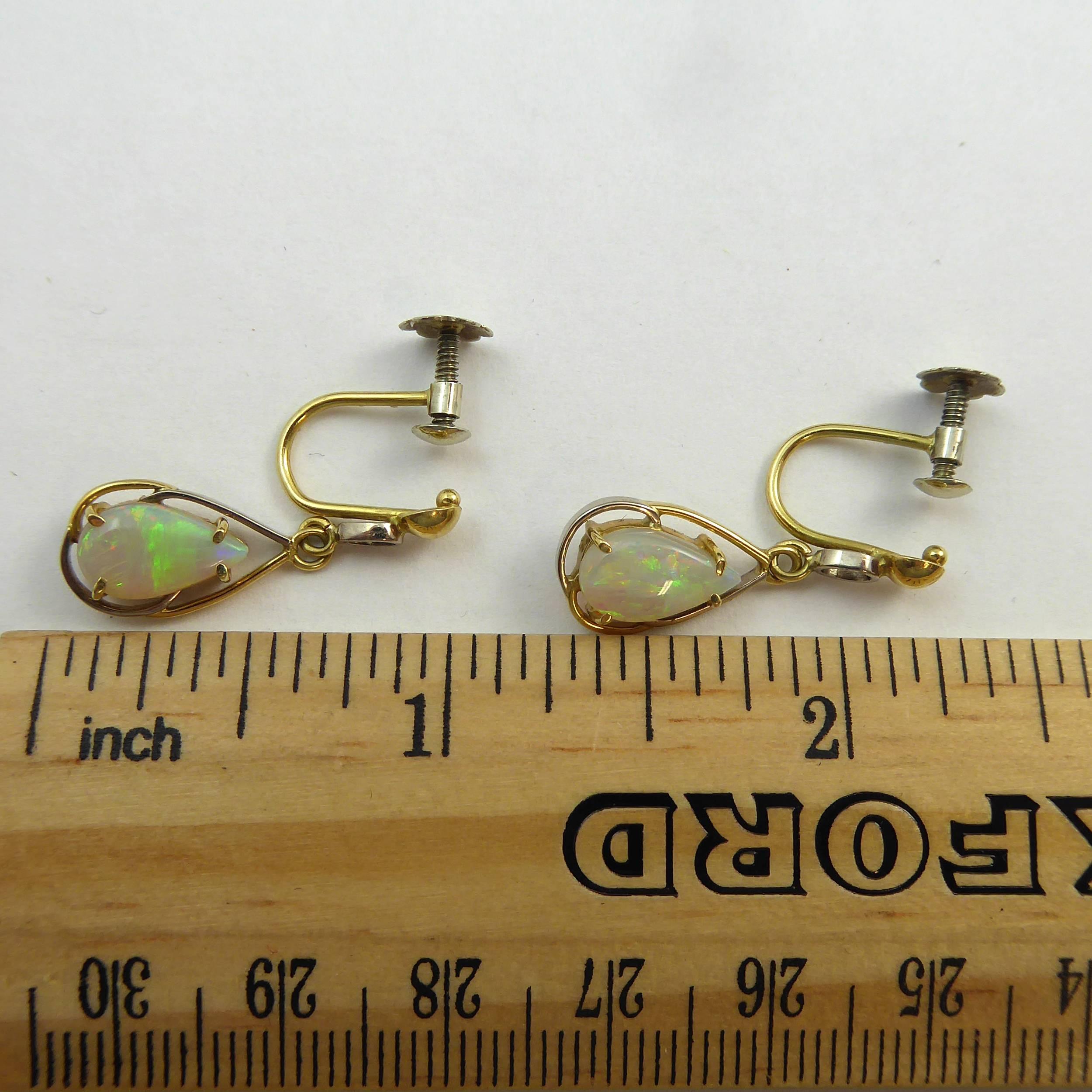 Vintage drop earrings each set with a pear shaped, cabochon cut opal with a strong blue/green play of colour.  Measuring approx. 12.5mm long x 7.5mm wide at the maximum point, the opals are yellow claw set to an open work pear shaped moount and