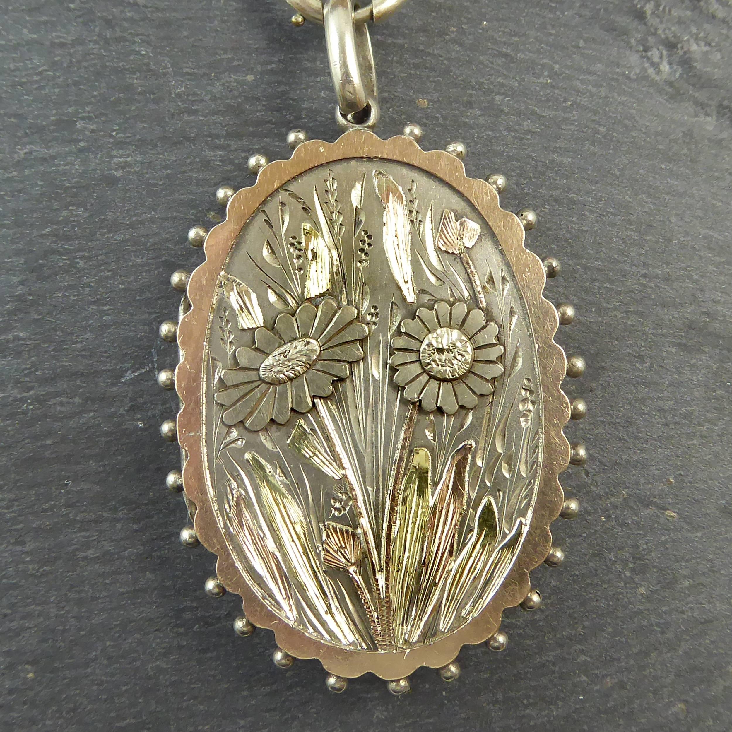 A sensational Victorian picture locket and collar created in silver with applied rose gold and gold decoration.  The locket is oval in shape and features to the front a floral Chinoiserie applied decoration in relief to a background engraved with a