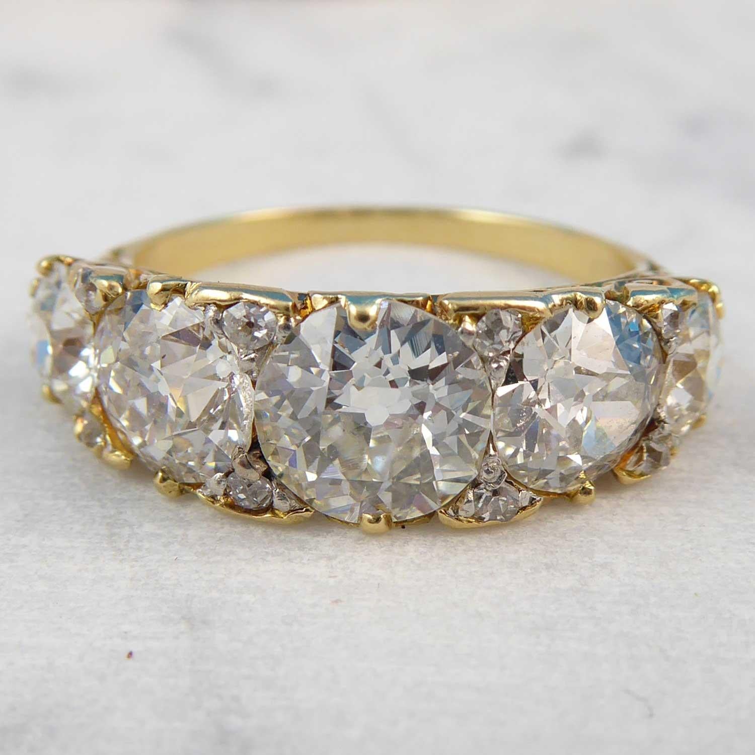 A Victorian diamond set five stone ring comprising five graduating old European cut diamonds measuring from 6.70mm diameter to 4.55mm diameter, claw set to a yellow boat shpaed head.  Beteween each of the main diamonds are a pair of claw set old