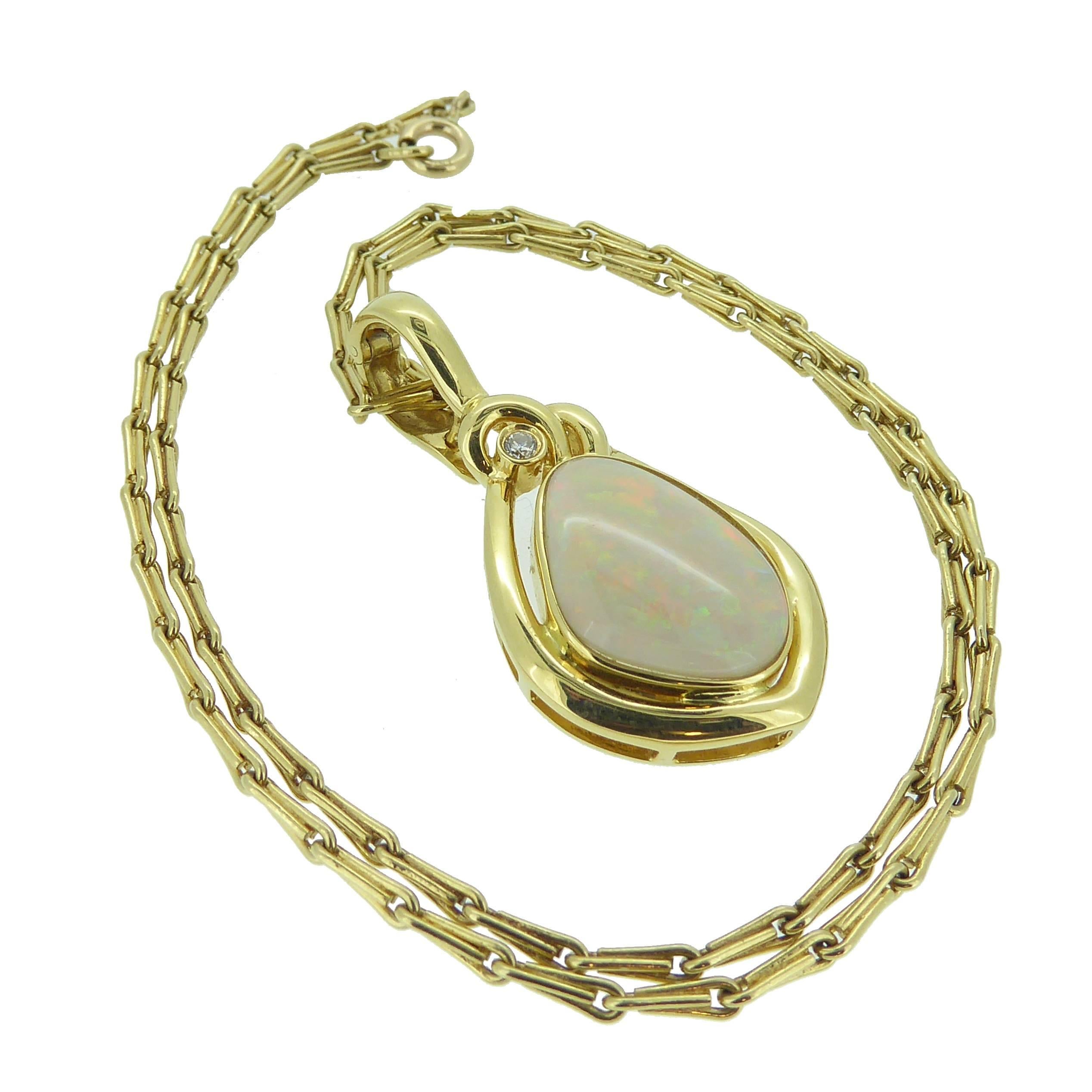 Something out of the ordinary with its off-oval shape and mirroring gold surround, this opal and diamond is set with a cabochon opal in a gold rub over setting compliments the rainbow hues of the of opal.  The single diamond feature at the top of