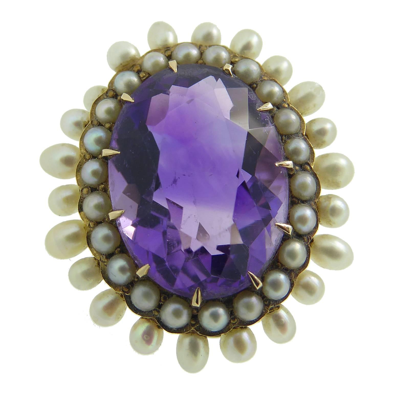 A lovely brooch, very dainty and set with a rich purple hued faceted amethyst, the colour of which is enhanced by the lustre of white pearls which surround it.  The amethyst is held in a setting of 10 yellow gold claws and enclosed within a surround