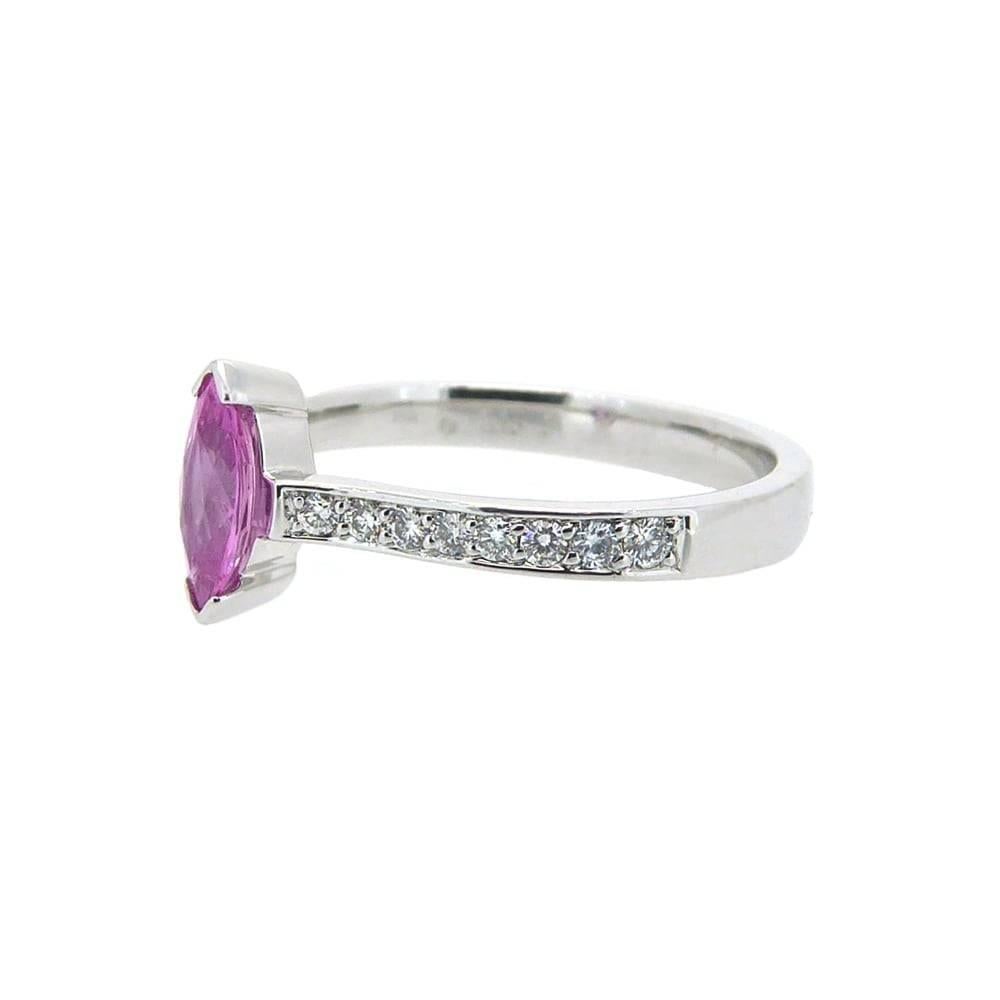 A very richly coloured, half carat pink sapphire which has been cut into a marquise shape and mounted in a part rub-over setting.  The shoulders each feature brilliant cut diamonds bead- set in a channel to a flat cross sectoned white band. 