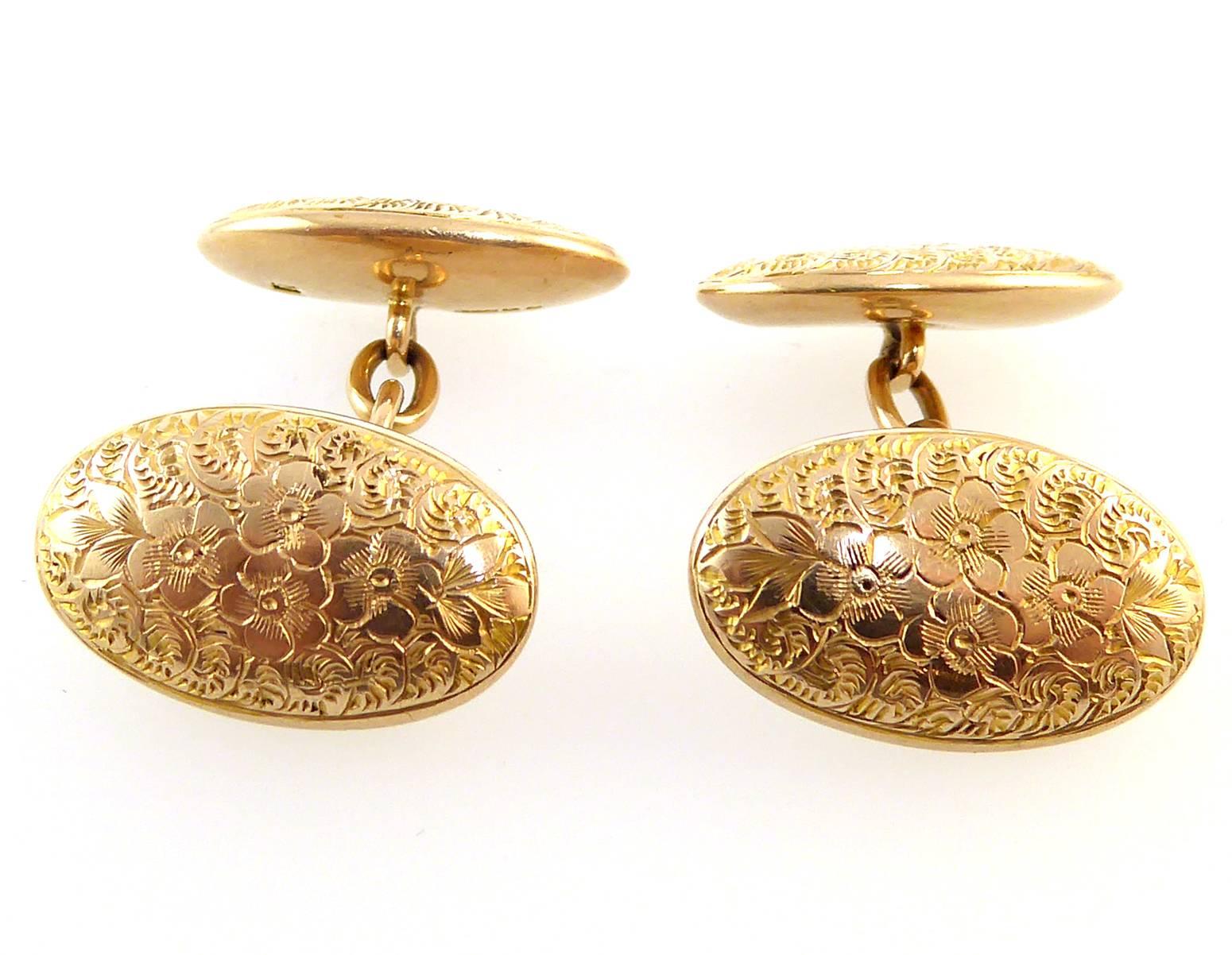 Beautifully hand engraved cufflinks with a posy of pansy-like blooms to the centre with a decorative swirl pattern edge.  The front and back of the cufflinks are very slightly domed.

Both links are engraved and are connection by oval gold links. 