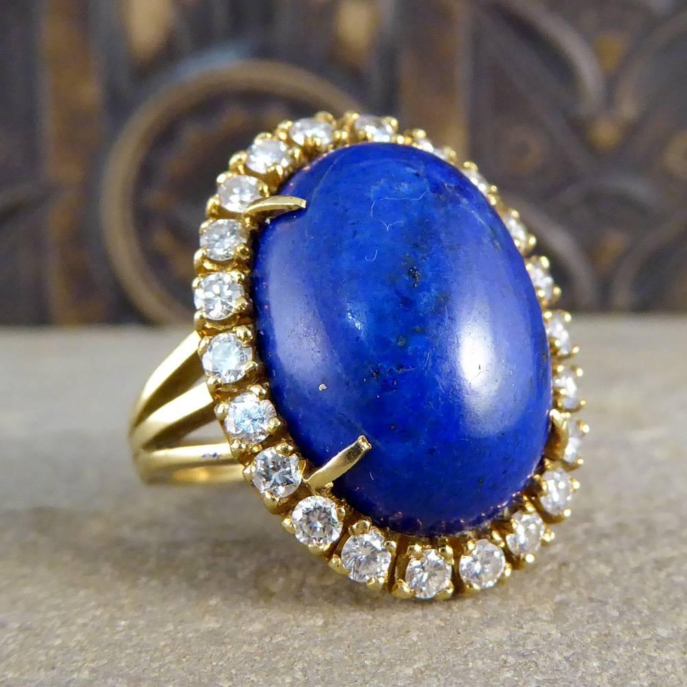 This bold vintage ring features a large lapis lazuli stone surrounded by twenty two diamonds. Set on an 18ct yellow gold band with triple split shoulders, it looks very compelling on the hand!

Ring Size: UK K 1/2 or US 5 1/2 

Condition: Very Good,