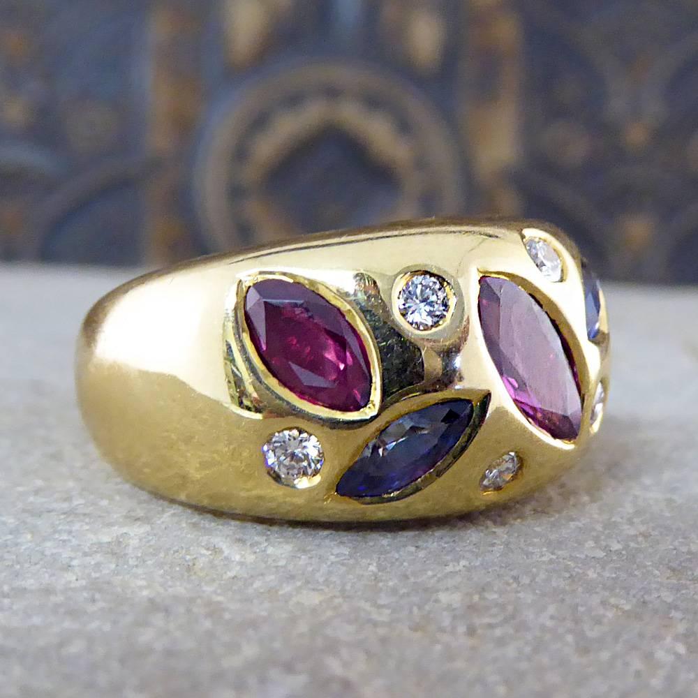 This 18ct gold contemporary gypsy ring is of heavy quality and features three rubies, two blue sapphires and six diamonds.

It is a fantastic statement piece with the gemstones adding a pretty pop of colour to this funky design!

Ring Size: UK N or