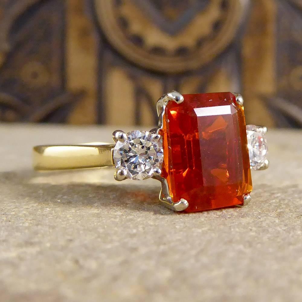 This contemporary ring features a truly stunning fire opal stone with two diamonds set in an 18ct white gold head, all set on an 18ct yellow gold band.

This bold and brilliant ring is sure to get you noticed!

Ring Size: UK N 1/2, US 7

Condition:
