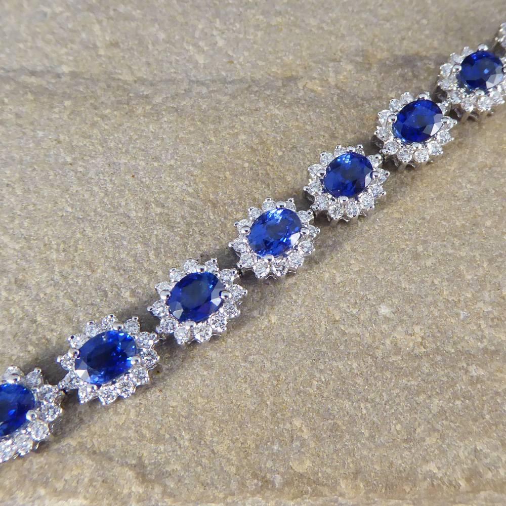 Such a beautiful and enchanting Sapphire and Diamond cluster bracelet which has been hand-crafted in 18ct white Gold. Each cluster consists of a ovaled blue Sapphire weighing 0.48ct sitting in the centre of 12 glittering modern brilliant cut