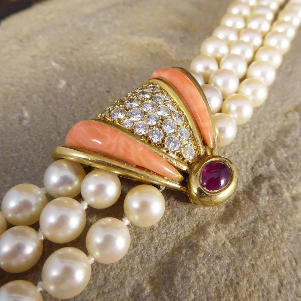 This great 1970's necklace has been connected through three strands of Pearls with an 18ct yellow Gold Clasp. Featuring one large Coral, Cabochon Ruby and Diamond beautiful centre in the middle of the bracelet, and with a matching bracelet (NJWB28)