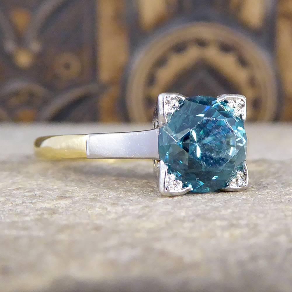 This gorgeous Art Deco ring features one single beautiful and vibrant blue Zircon, in a platinum square setting. The platinum setting has a simple and elegant design from the side profile and leads down the shoulders to the 18ct Yellow Gold band.