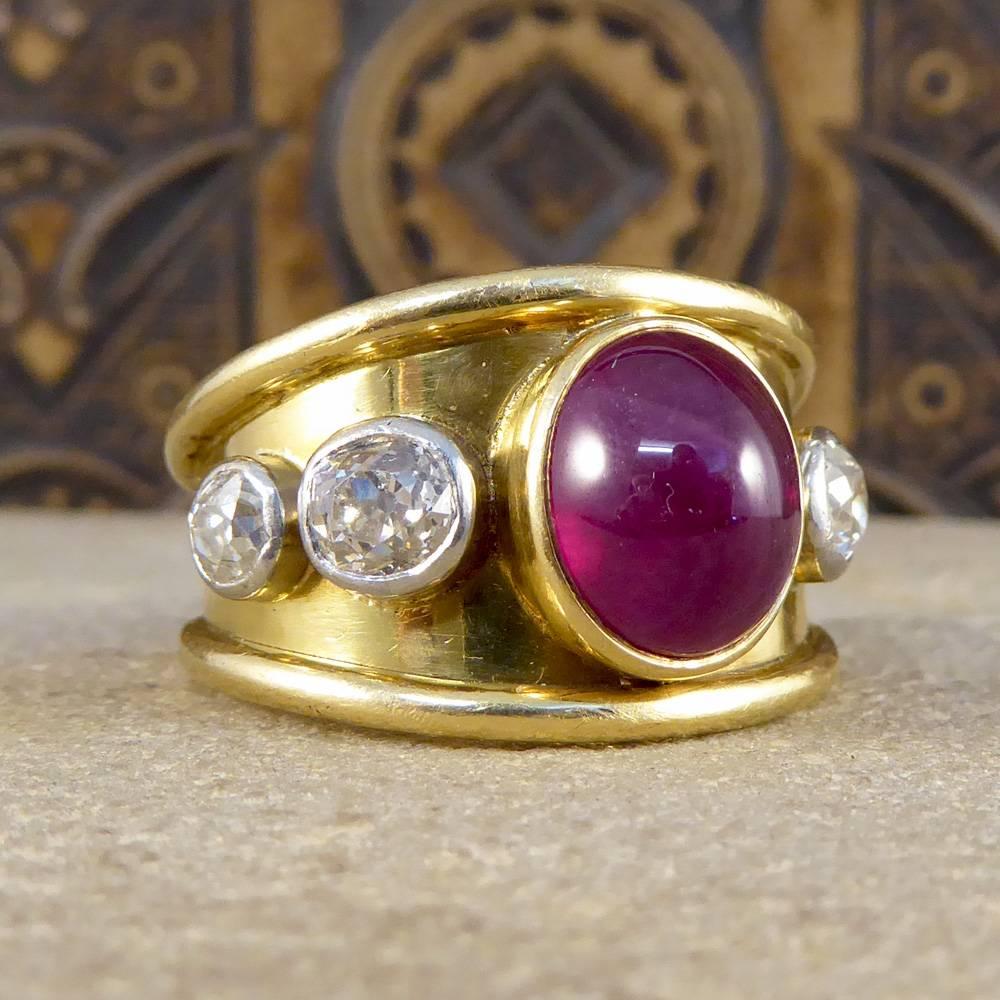 Large in size and in character, this ring holds a deep red domed Cabochon Ruby in the centre accompanied by four Old-cut Diamonds. The Diamonds graduate in size on each side of the Ruby with the largest Diamonds sat next to the Ruby and the smaller