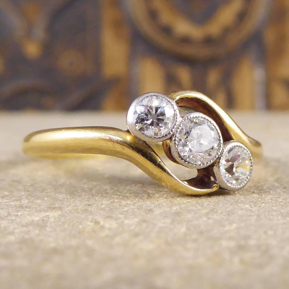 A very elegant three stone diamond ring that is set with three sparkling diamonds. The band is 18ct yellow gold with a platinum top and the stones are millegrain set. A very pretty piece! 

Ring Size: UK R 1/2 or US 8.75

Condition: Very Good,