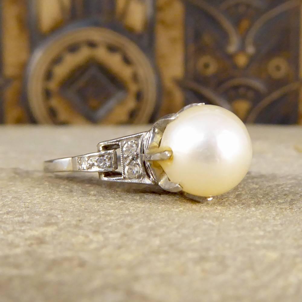 This showstopper ring features one large cultured Pearl held securely into place with an eight claw set shank with a pin running through the Pearl. Adorned with a Diamond detail on either side, this ring has been hand crafted from 18ct White Gold
