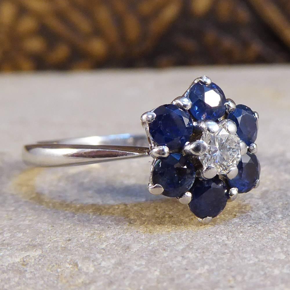 This stunning floral cluster ring is of wonderful quality and is signed GRAFF, the world renowned diamond company. It features six sapphire stones surrounding a single diamond set in an 18ct white gold band. 

It will make a fabulous engagement