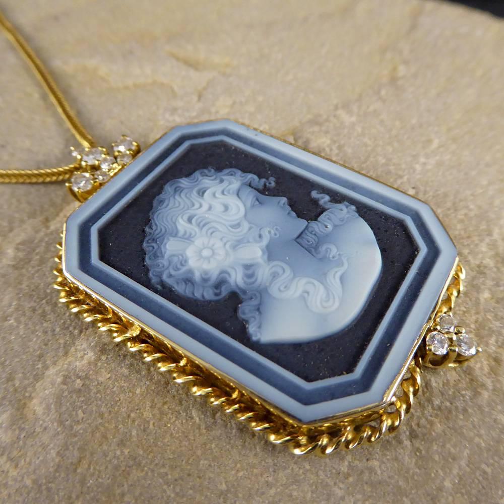 This wonderful pendant features a ladies profile portrait in banded agate stone. This is set in a detailed 18ct gold frame nestled in between two diamond clusters.

It rests on an 18ct gold chain which has a 9ct gold clasp. Classic and charming,