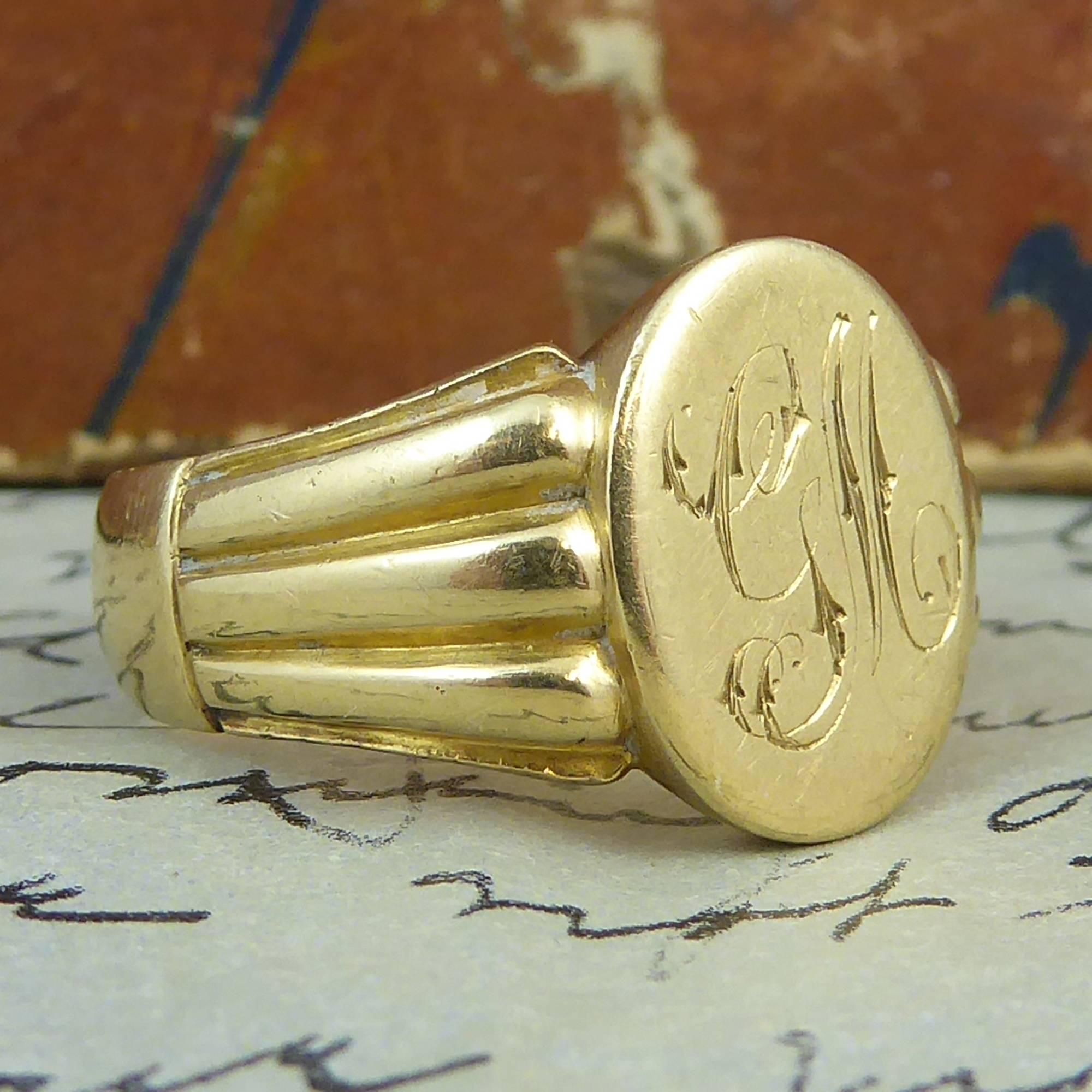 An antique signet ring of truly fabulous quality.  Created in 18ct yellow gold, the signet ring has an oval head bearing some very finely engraved initials, G.M., in classic script style.  Highly decorative shoulders of three raised reeded pattern
