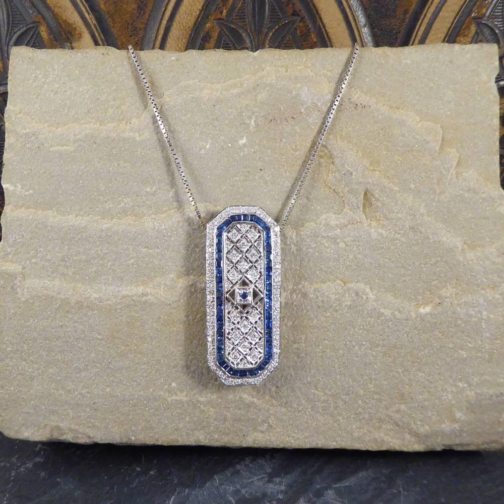 This contemporary pendant features a single blue sapphire centre stone surrounded by a diamond grid.

With two rows of calibre cut sapphire stones and diamonds, this stylish decorative piece come on an 18ct white gold chain, and can also be worn as