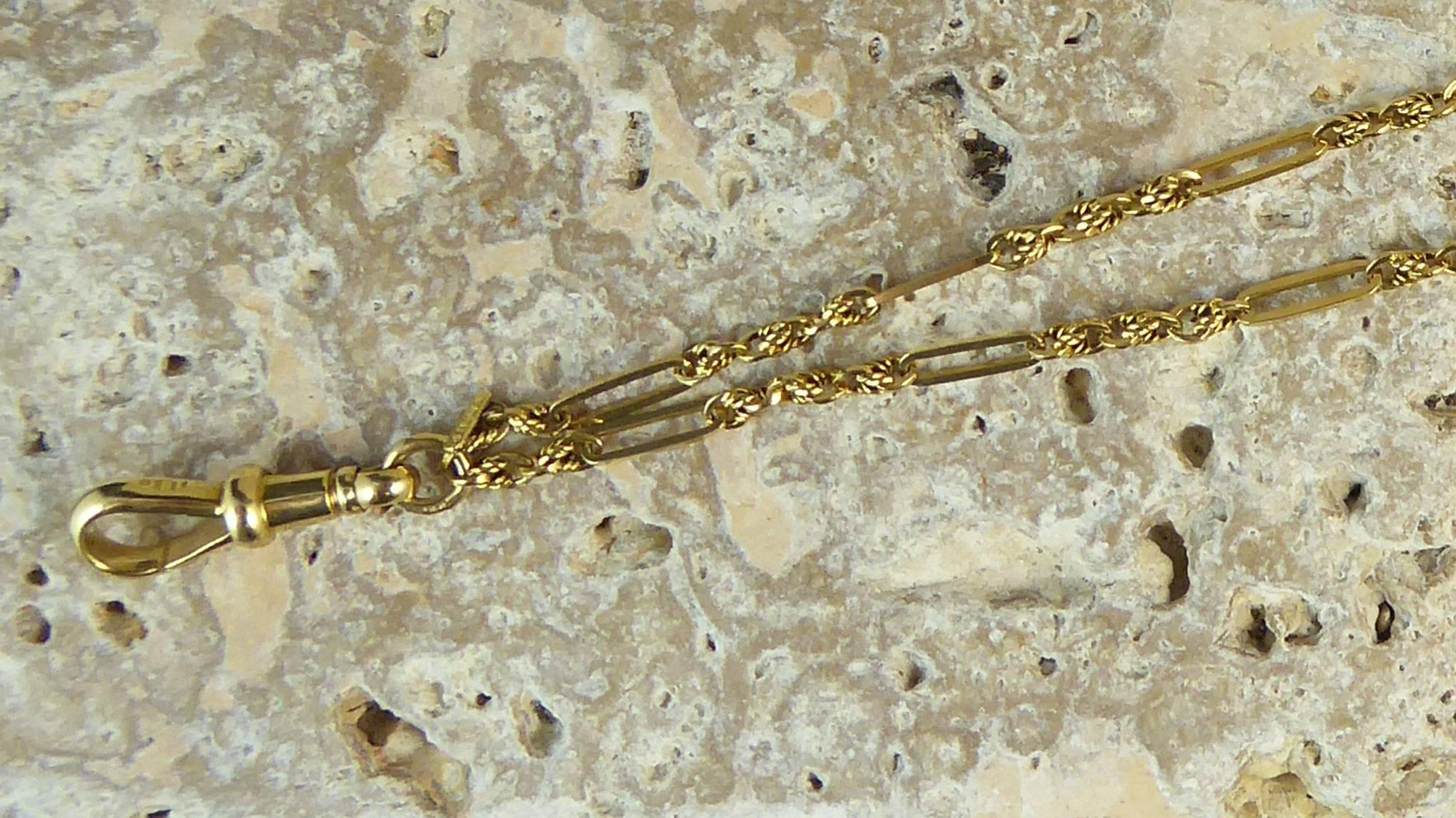 An antique Victorian Muff or Pocket Watch Chain in 18ct Yellow Gold.  Originally used by elegant ladies to run through a fur muffler and alternatively used as a pocket watch chain where the watch would be attached to the clip and then chain then