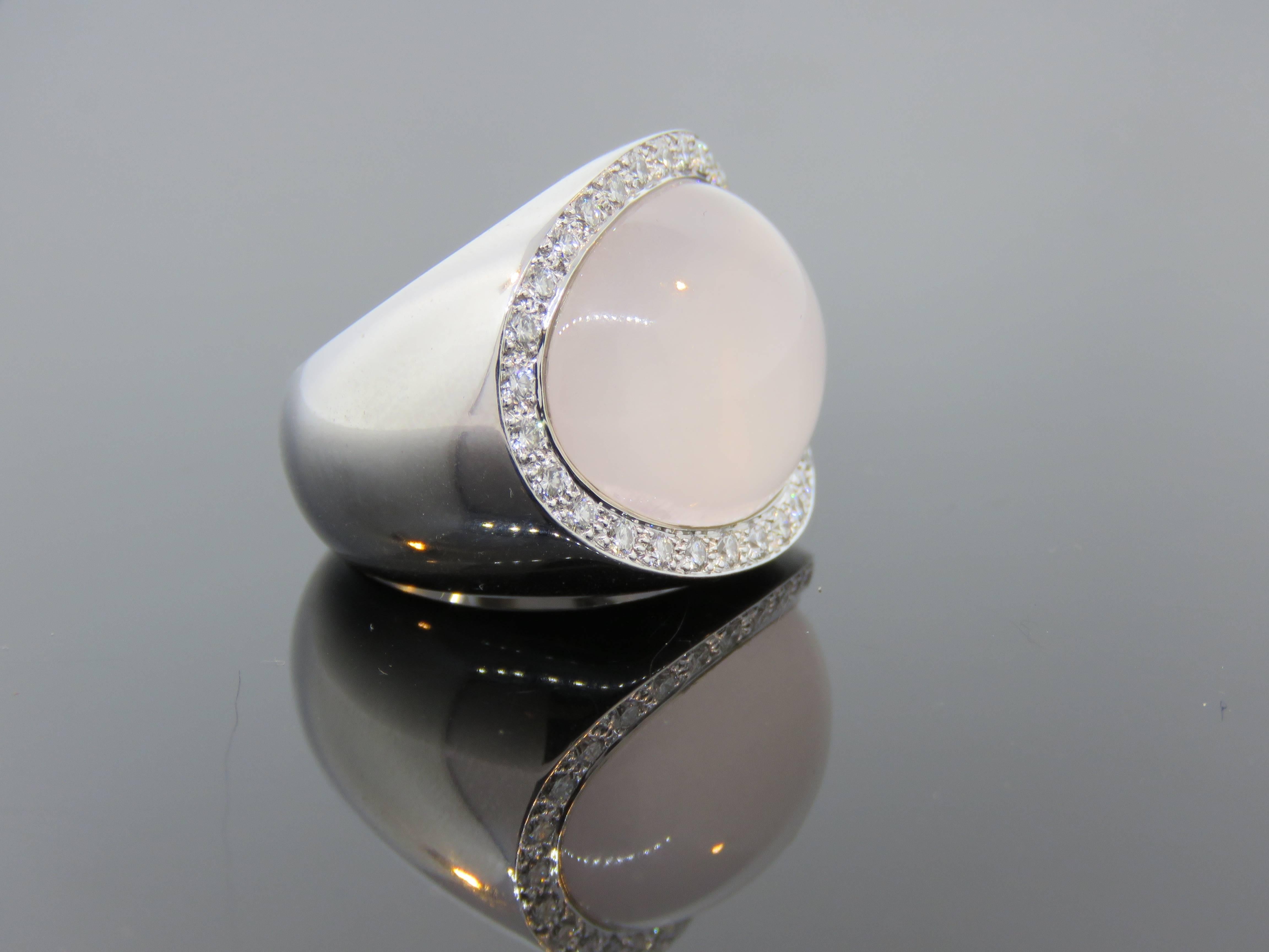 Van Cleef & Arpels unique 18k white gold, lavender moonstone, and diamond ring. The center curved cabochon moonstone is surrounded by 32 white, round, brilliant cut diamonds that total 1 ct. The hallmark on the ring reads,