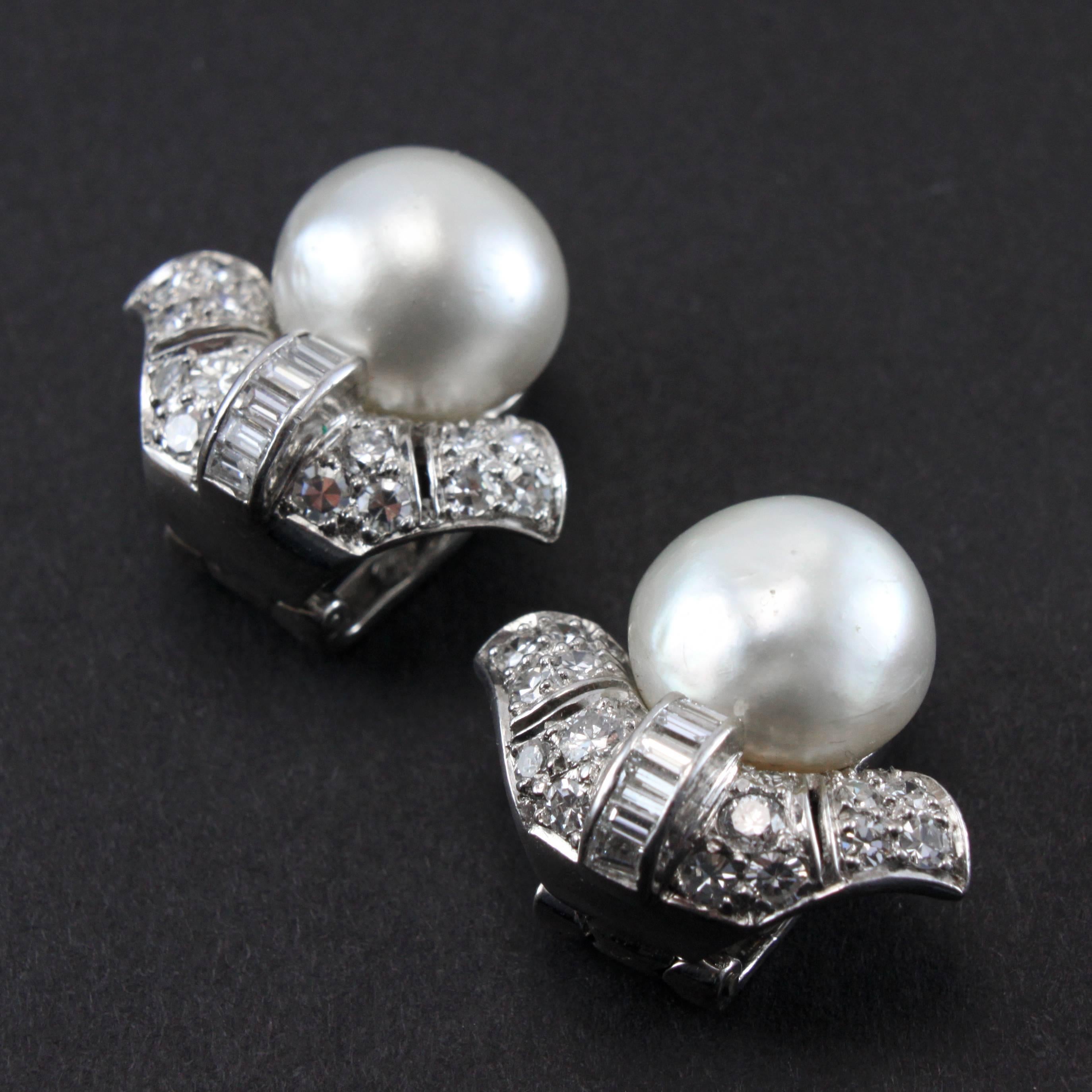 A fine and important pair of Art Deco Natural Saltwater Pearl and Diamond Earclips, ca. 1920s. The earrings are very beautifully made in the design of the lily of the valley flower. The large natural saltwater pearls (diameters of 11.4mm & 11.3mm,