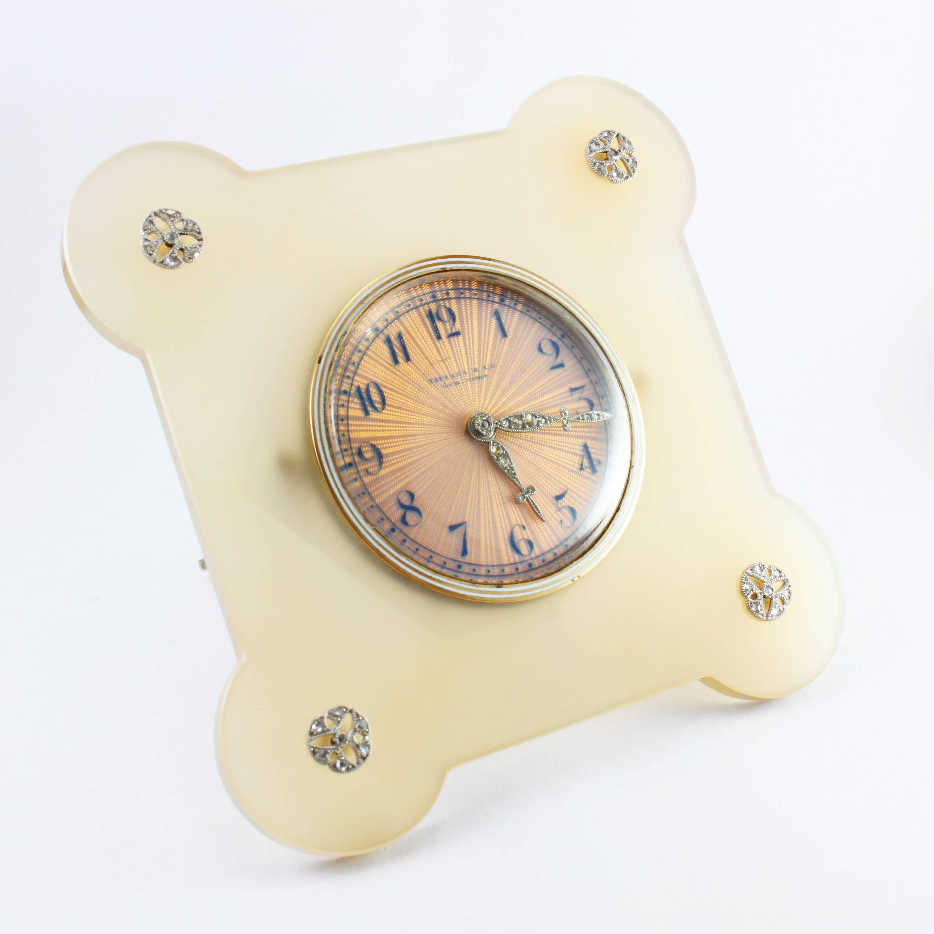 An important Art Deco Tiffany & Co Diamond and Agate Desk Clock, ca. 1920s

The desk clock is based on an agate with rounded corners, each centring a floral diamond cluster. 

The clock's dial is beautifully made in a reflective salmon-colored