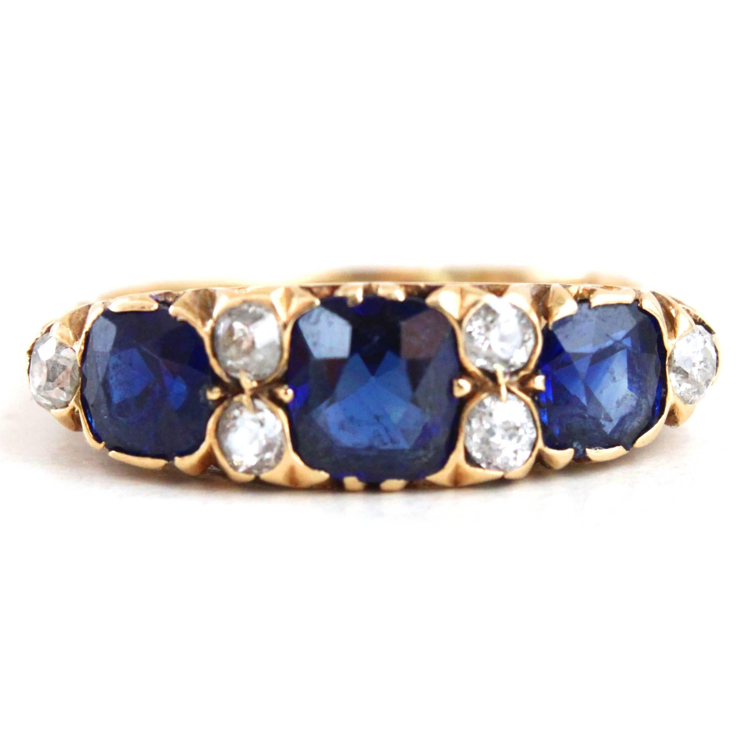 An elegant Victorian Sapphire and Diamond Ring, ca. 1890s set in 18k yellow gold with three very well saturated sapphires, surrounded by old-cut diamonds.

Hallmarked and signed.
Ring size 7.5 (can be altered).