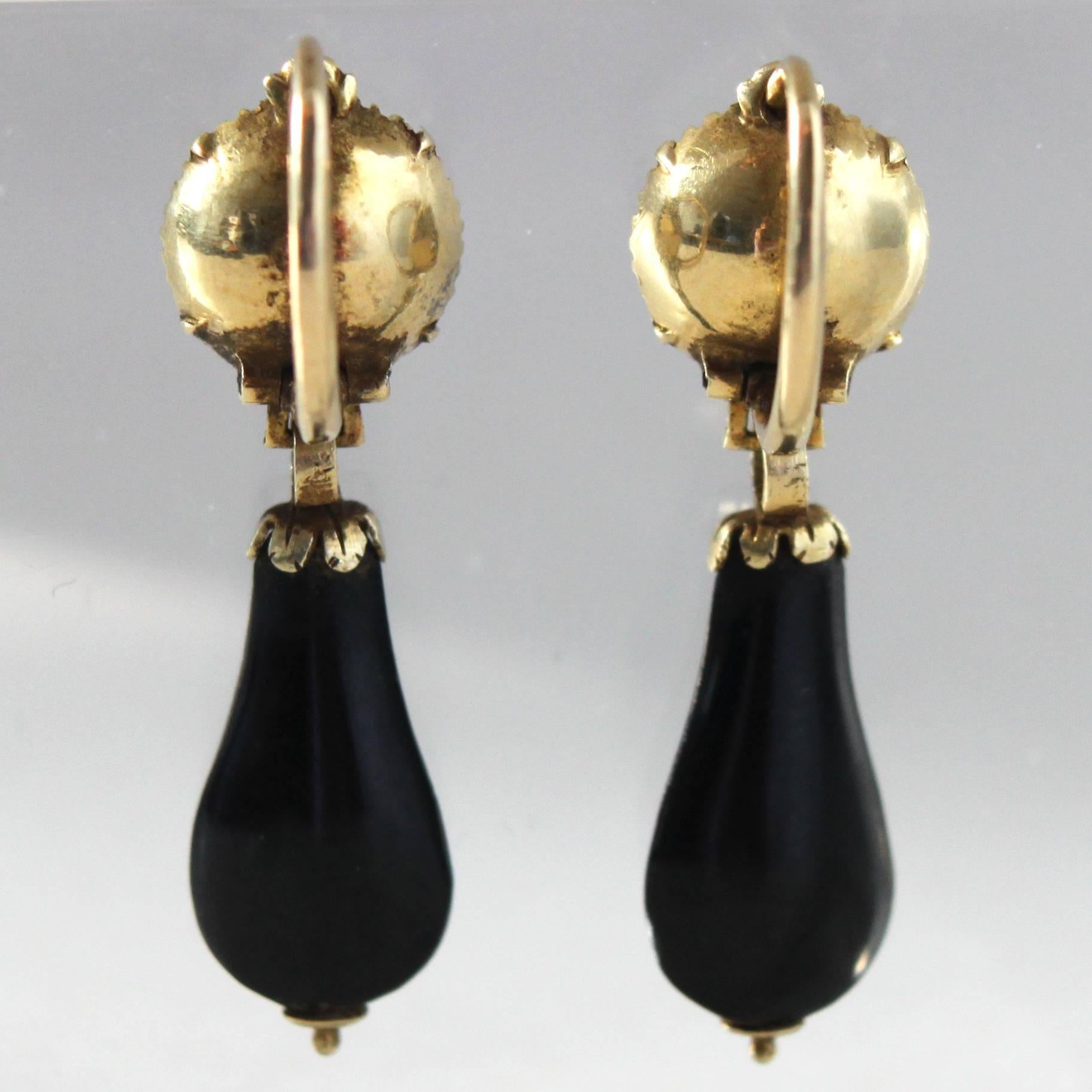 Antique pair of Victorian Onyx Pendant Earrings, ca. 1870s

A sleek pair of black onyx and gold hoop earrings, consisting of two onyx boutons (9mm) and two onyx drilled drops (16x9mm).

The earrings would be perfect for any black/white evening